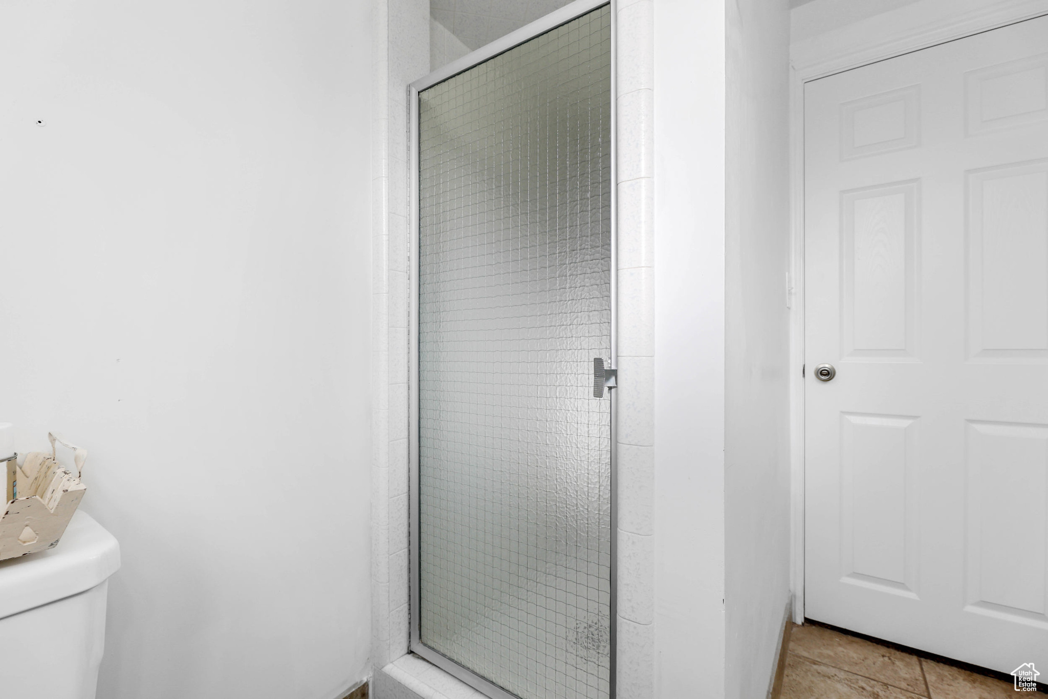 Full bathroom featuring a stall shower and toilet