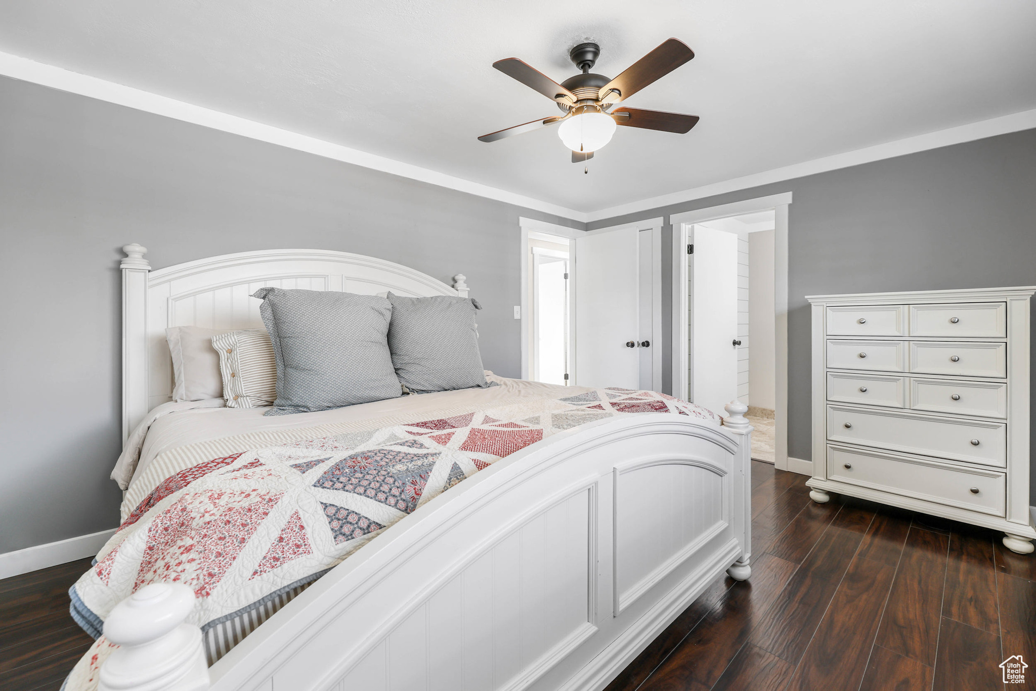 Bedroom with a ceiling fan, dark wood-type flooring, and baseboards