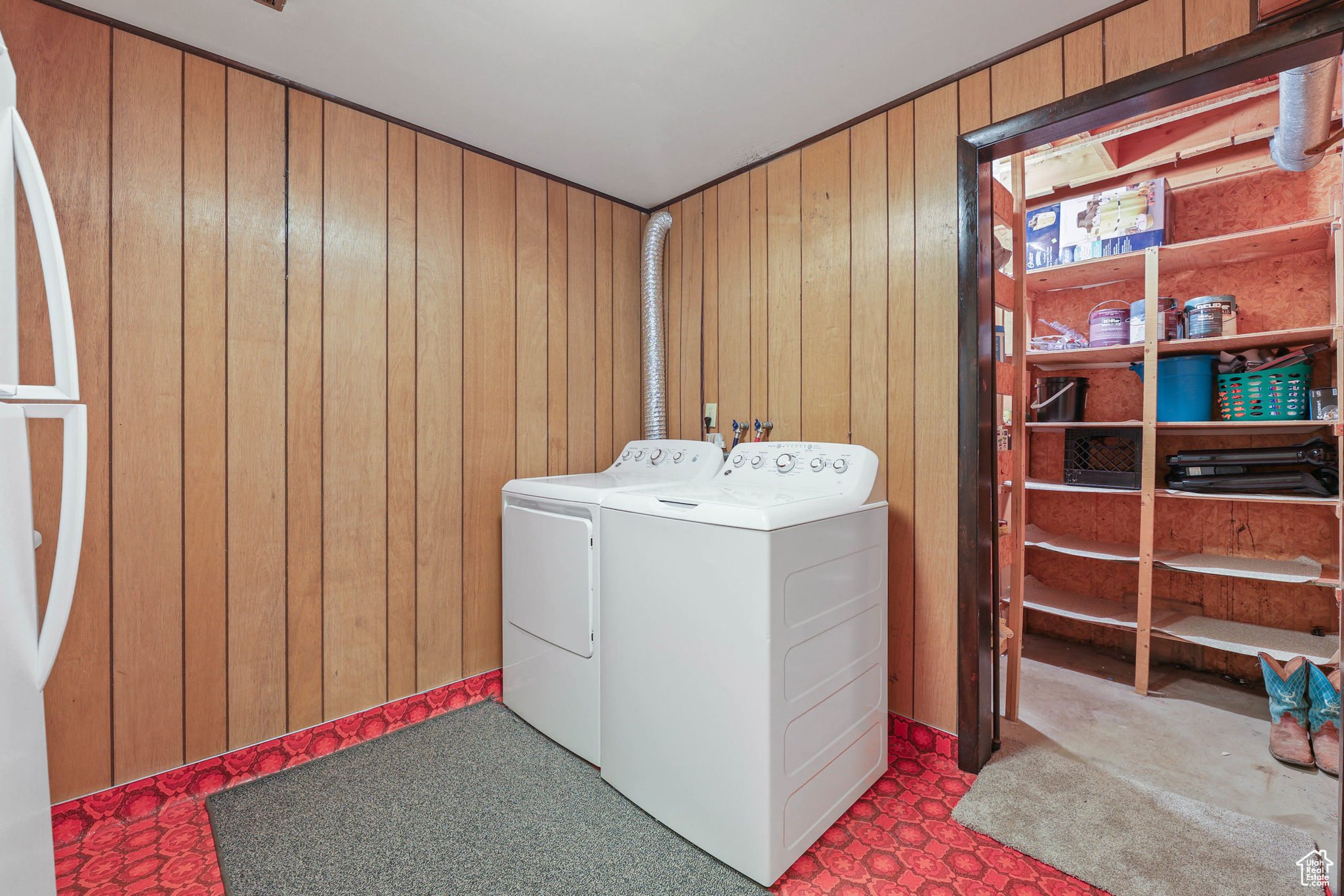 Washroom featuring wooden walls, washer and dryer, and laundry area