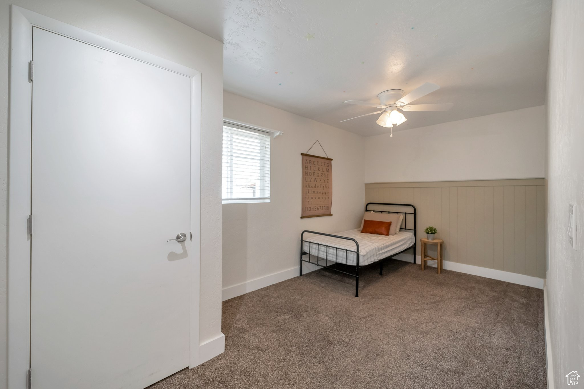 Bedroom with carpet flooring, wainscoting, baseboards, and ceiling fan