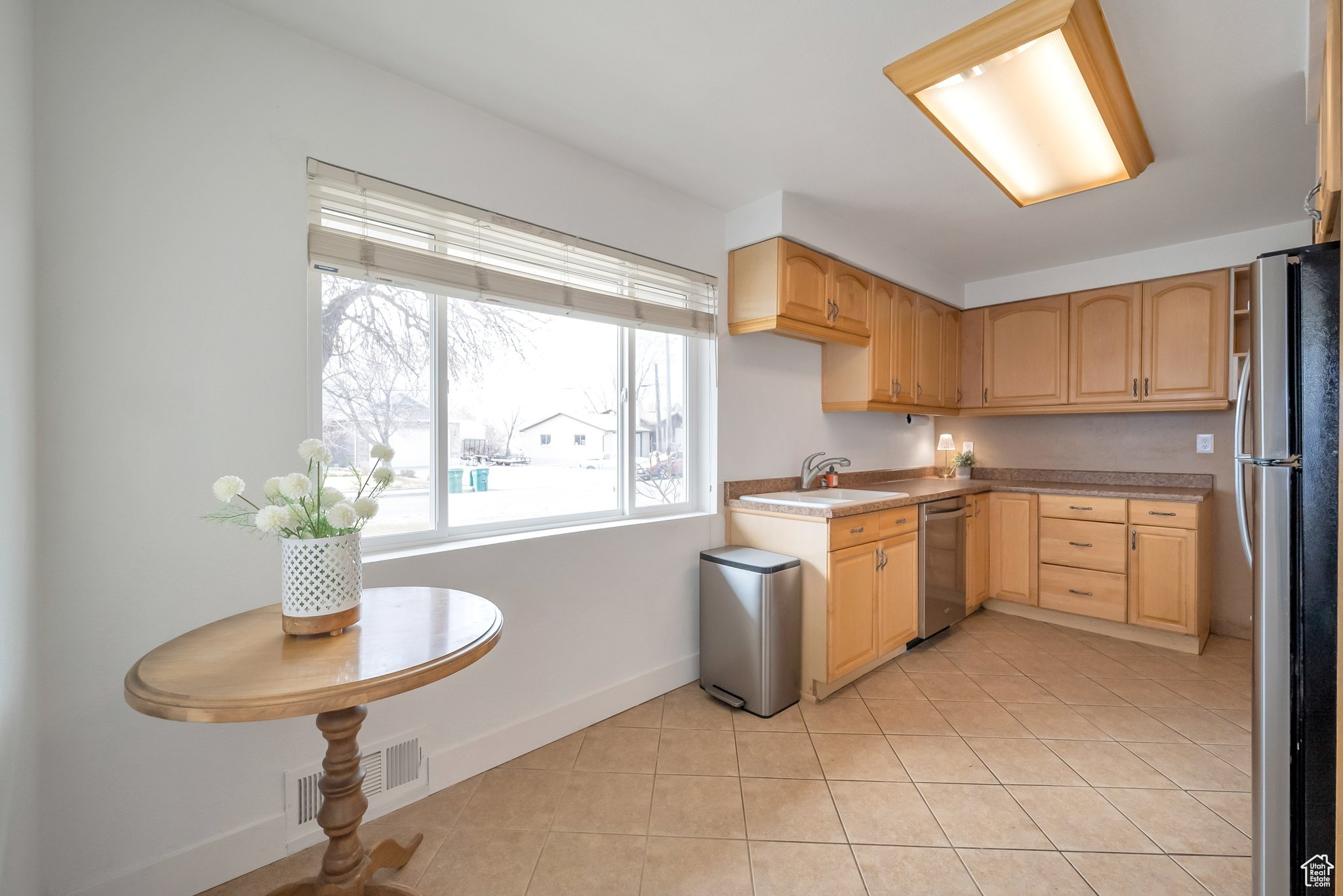 Kitchen featuring visible vents, light brown cabinets, a sink, appliances with stainless steel finishes, and light tile patterned flooring