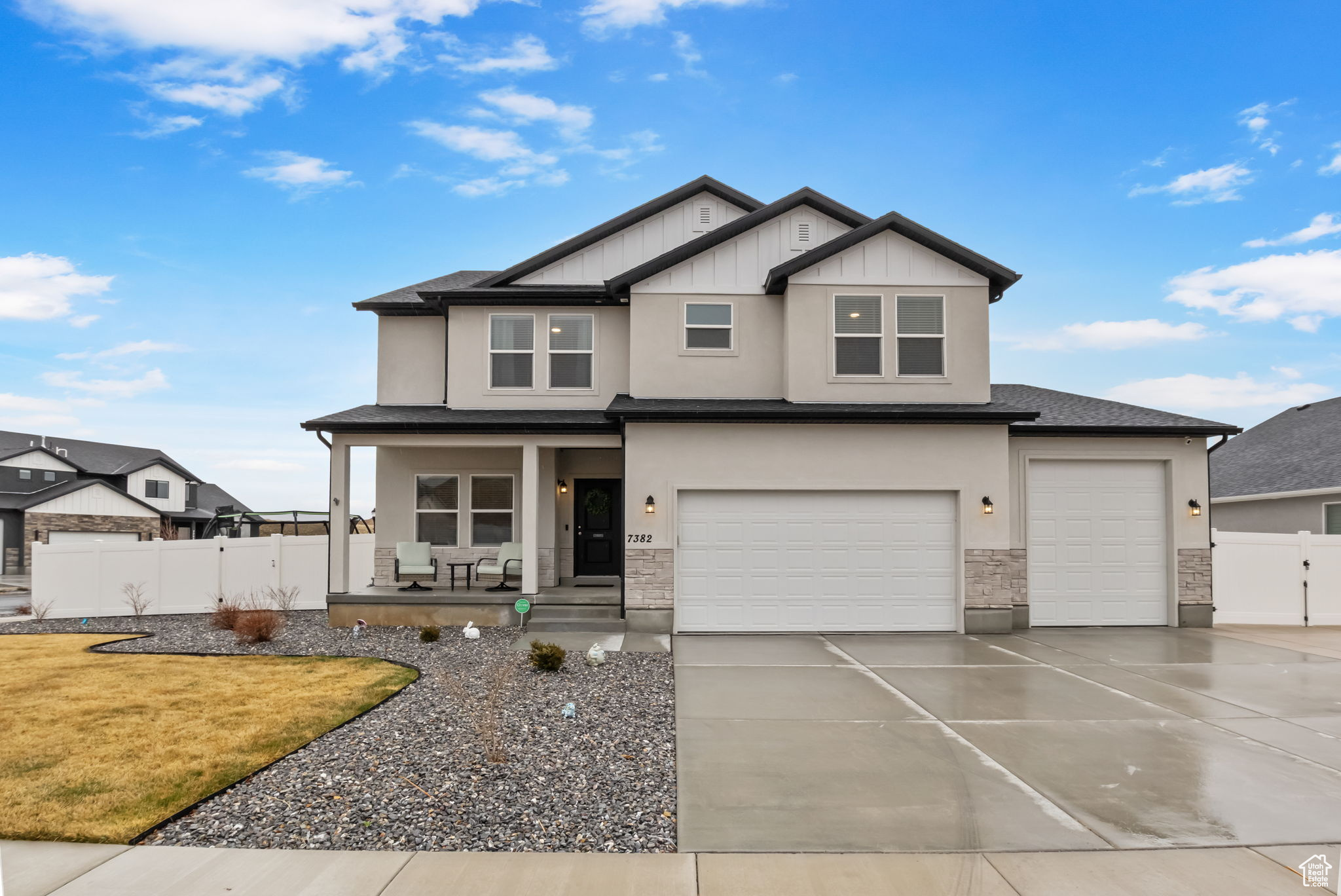View of front of home featuring driveway, stone siding, a porch, fence, and an attached garage