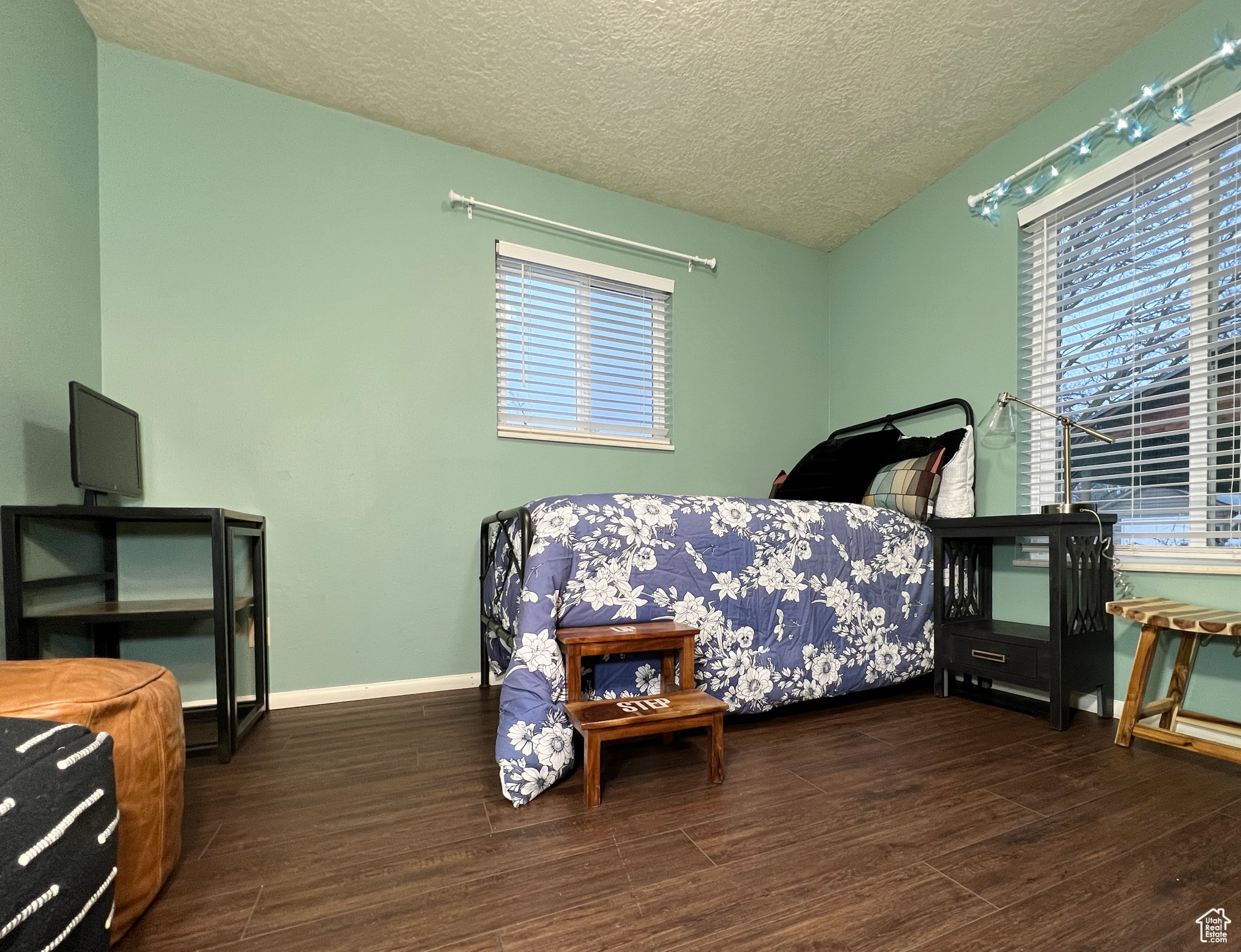 Bedroom featuring wood finished floors, baseboards, and a textured ceiling