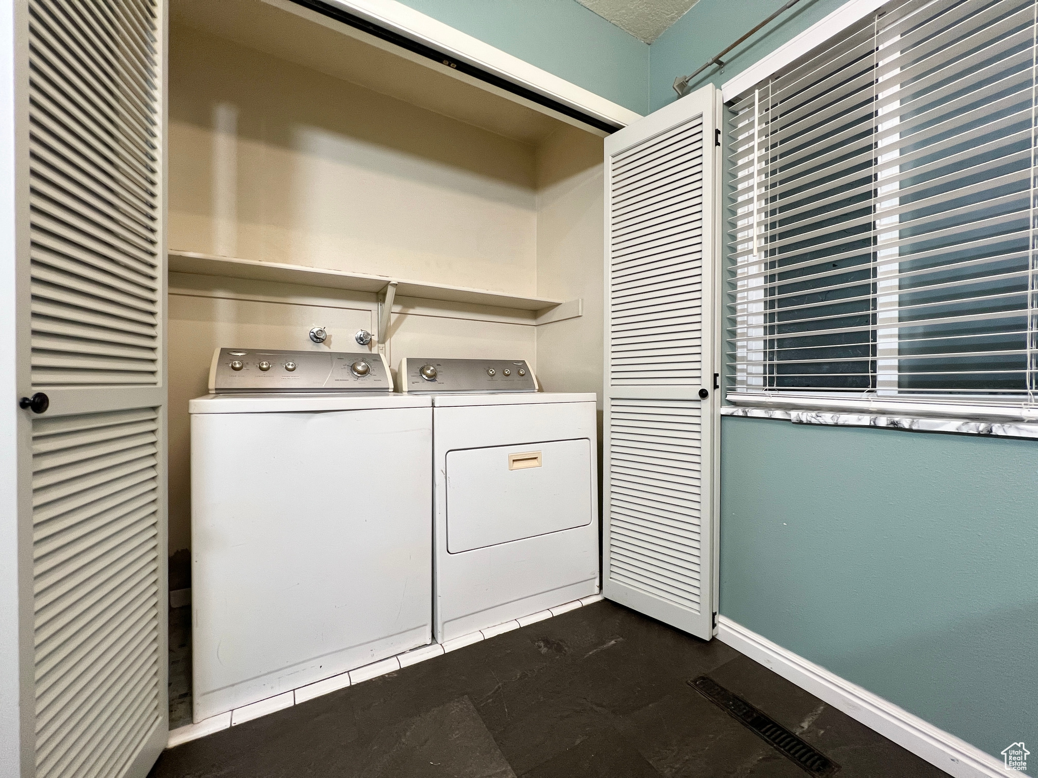 Clothes washing area featuring washing machine and clothes dryer, laundry area, and baseboards