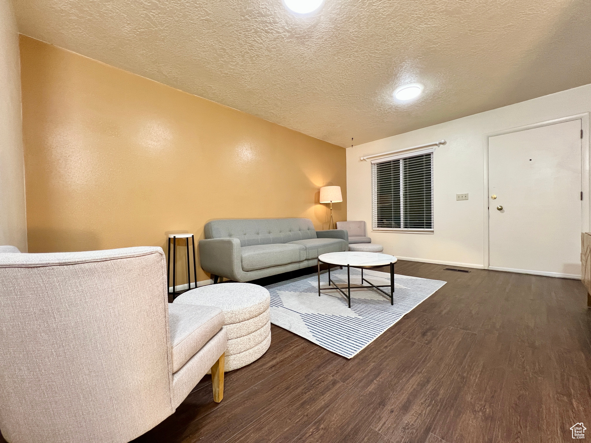 Living area featuring wood finished floors, baseboards, and a textured ceiling