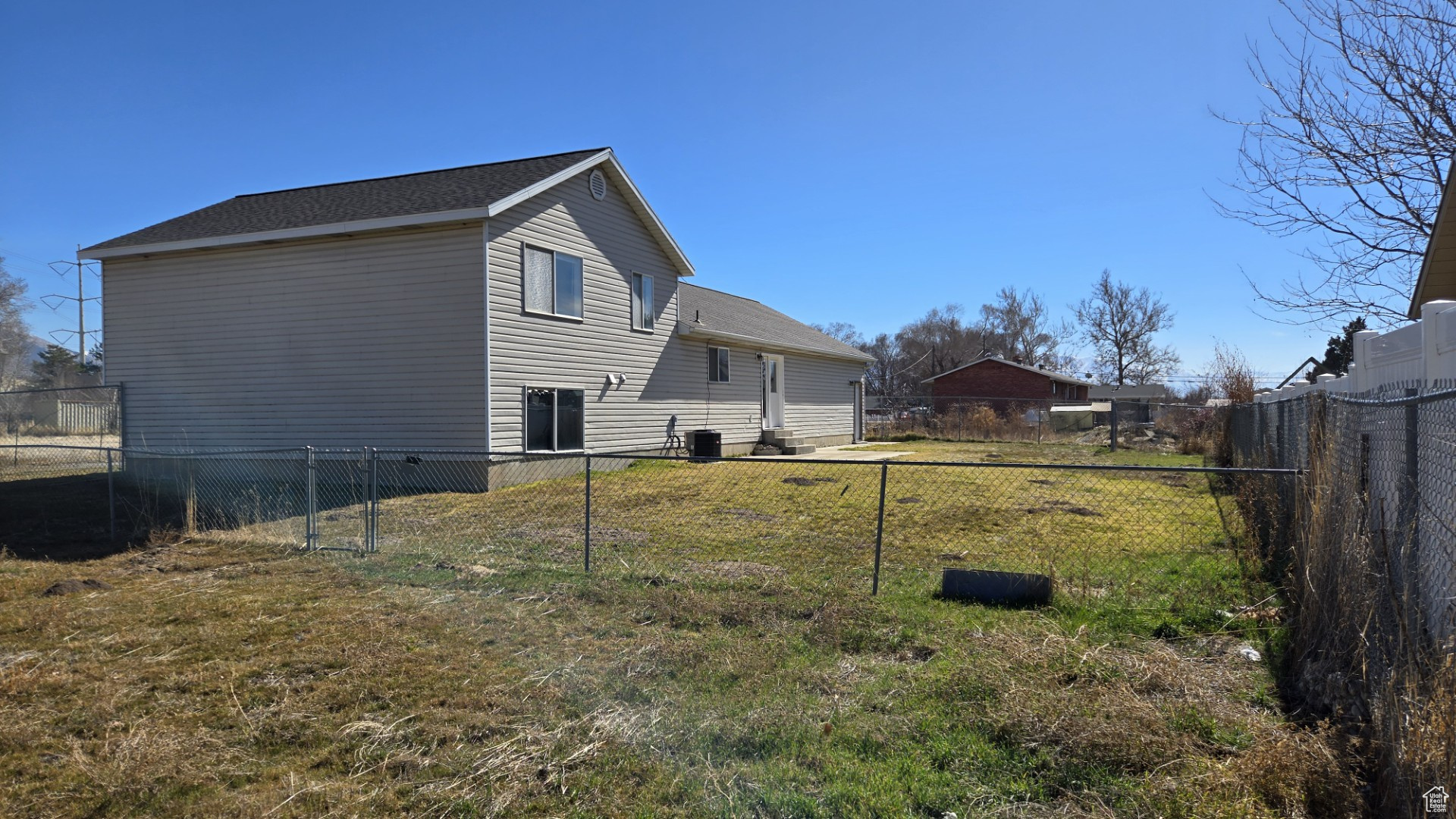 Exterior space featuring a yard, central AC, and a fenced backyard