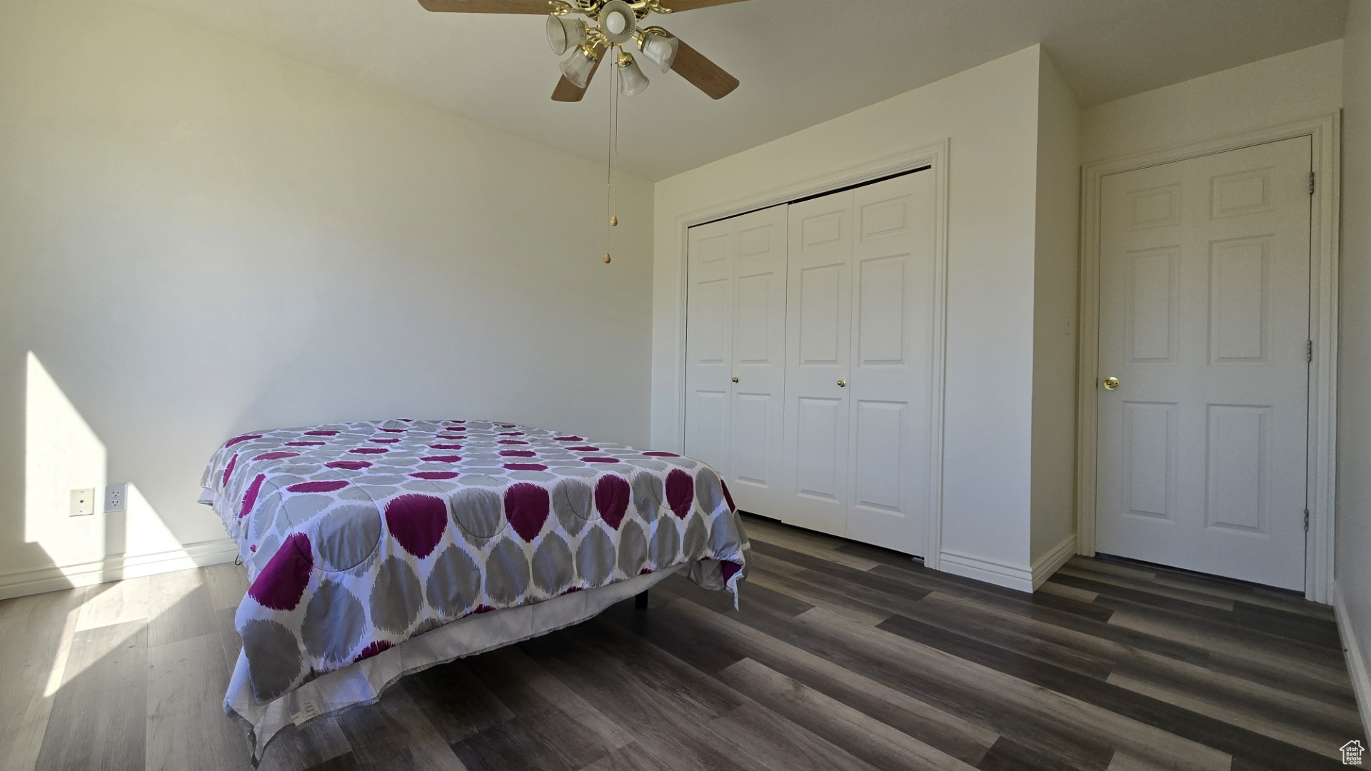 Bedroom with a closet, a ceiling fan, baseboards, and wood finished floors