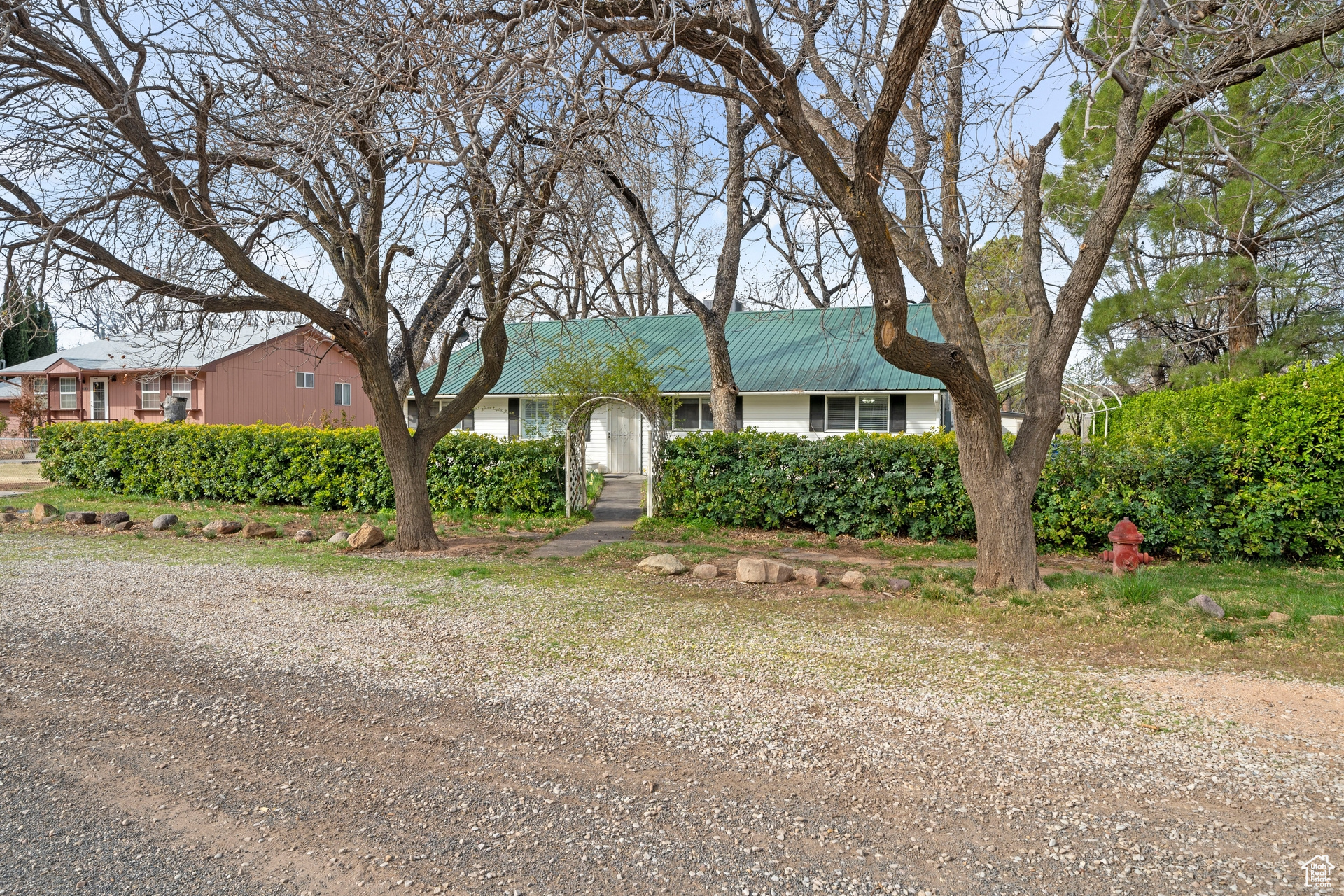 Front of home with arch and shrubbery for privacy