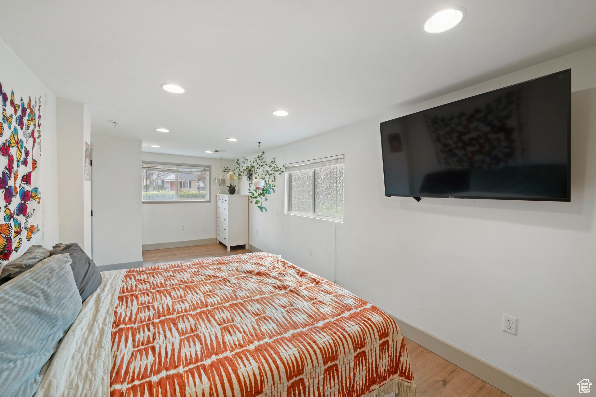 Bedroom with recessed lighting, multiple windows, baseboards, and wood-type flooring