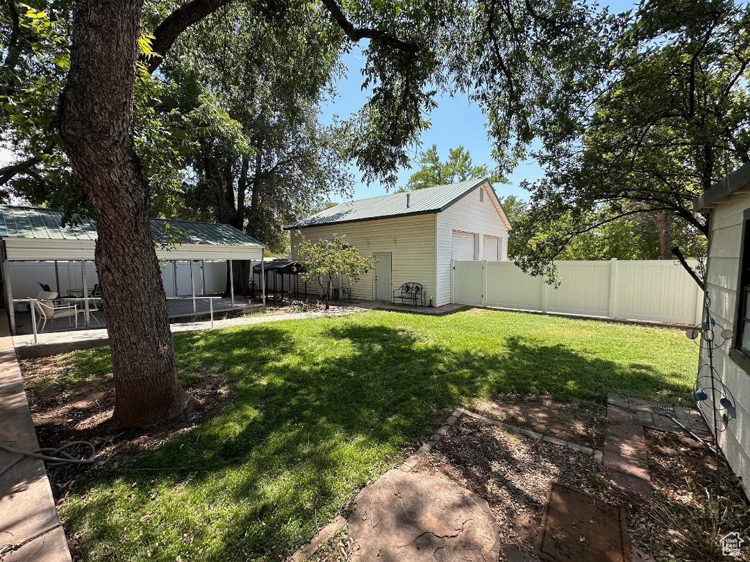 View of fully fenced backyard featuring a covered patio