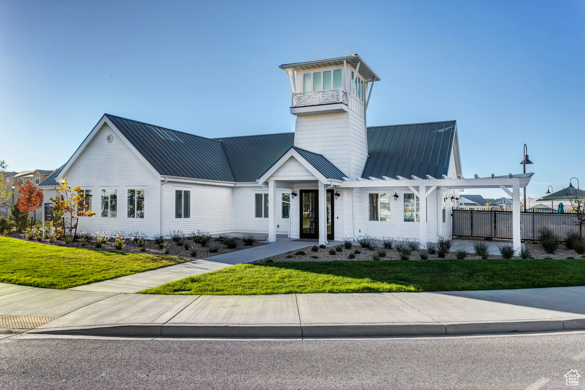 View of front of property featuring metal roof, a front lawn, and fence