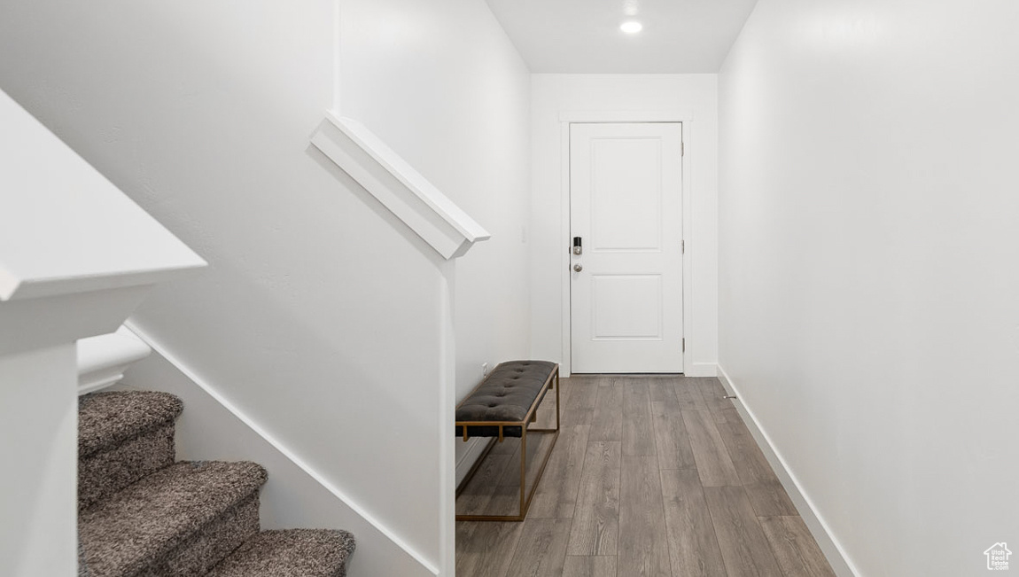 Staircase with wood finished floors and baseboards