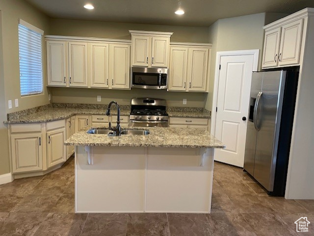 Kitchen featuring granite countertops, a center island with sink, recessed lighting, stainless steel appliances.