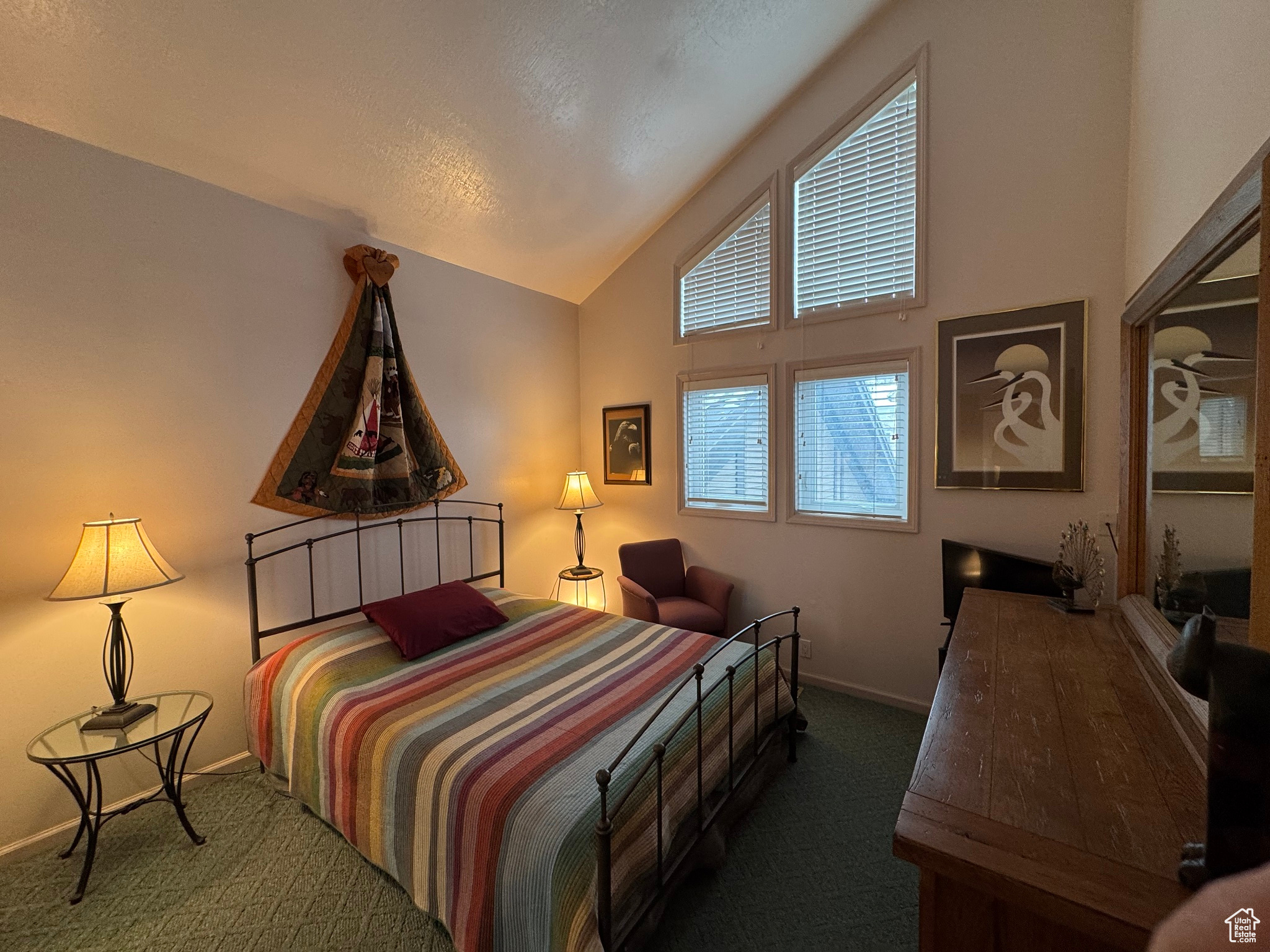 Bedroom featuring baseboards, carpet flooring, and vaulted ceiling