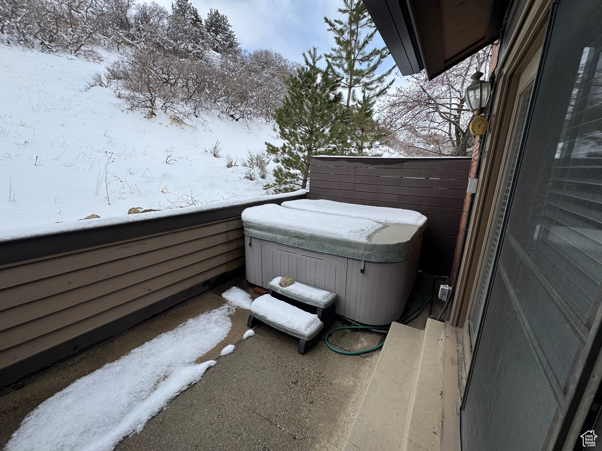 Exterior space with a hot tub and a patio.