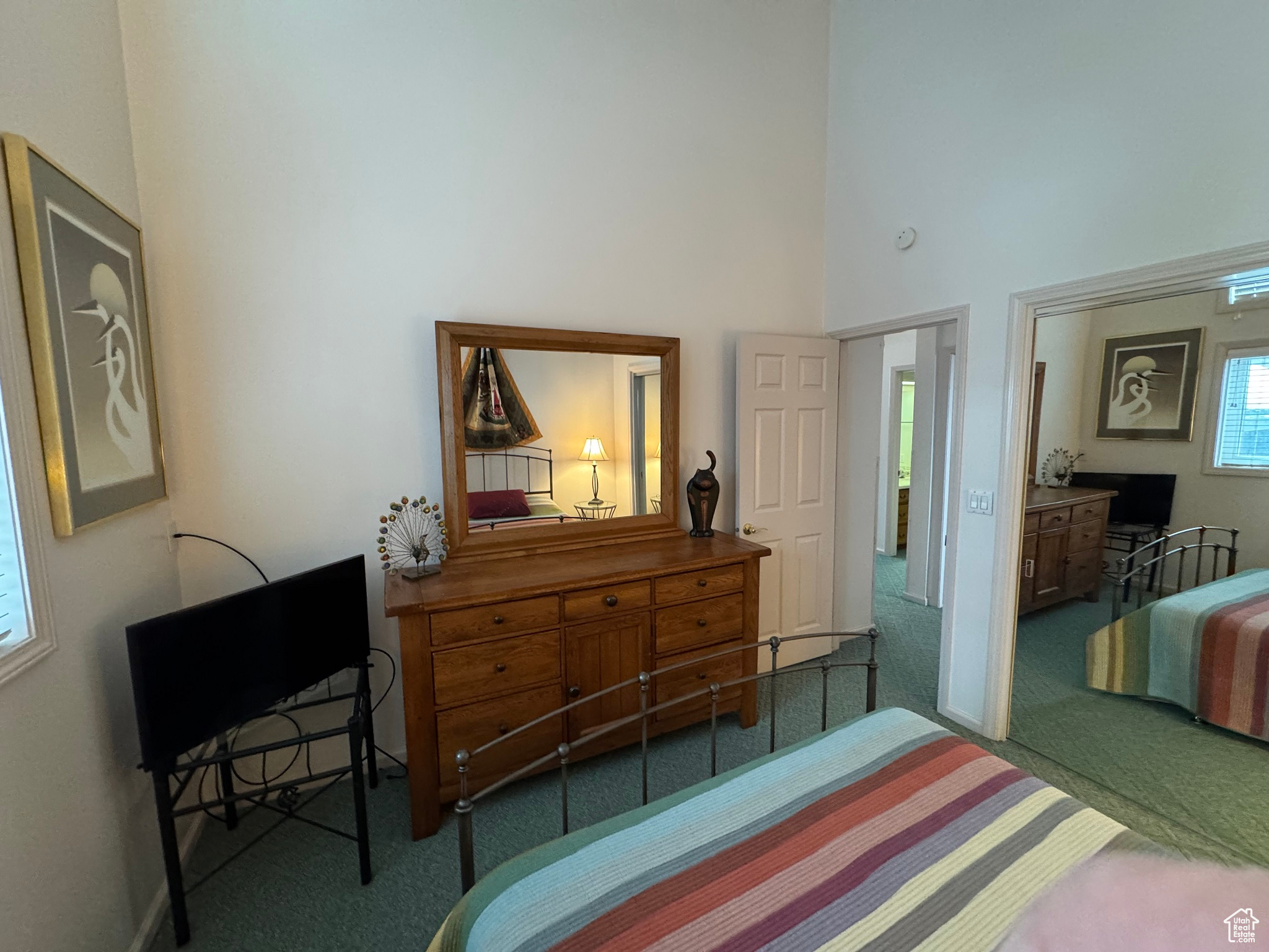 Carpeted bedroom featuring a towering ceiling