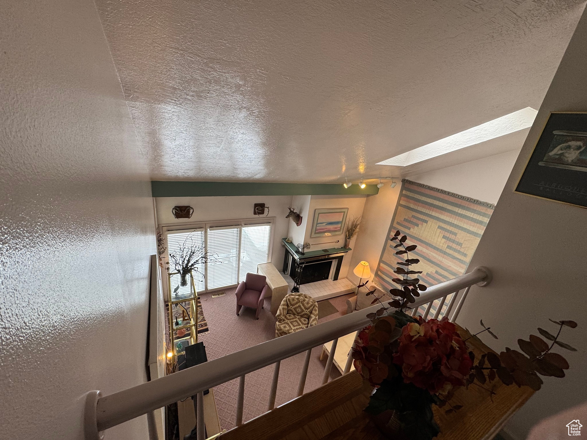 Stairs with a textured ceiling, a skylight, and a textured wall