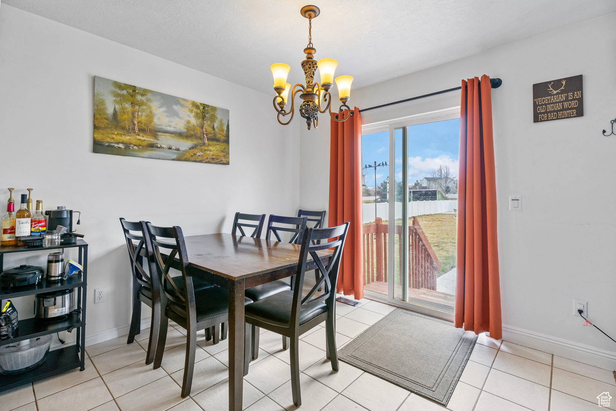 Dining area featuring light tile patterned floors, baseboards, and a chandelier