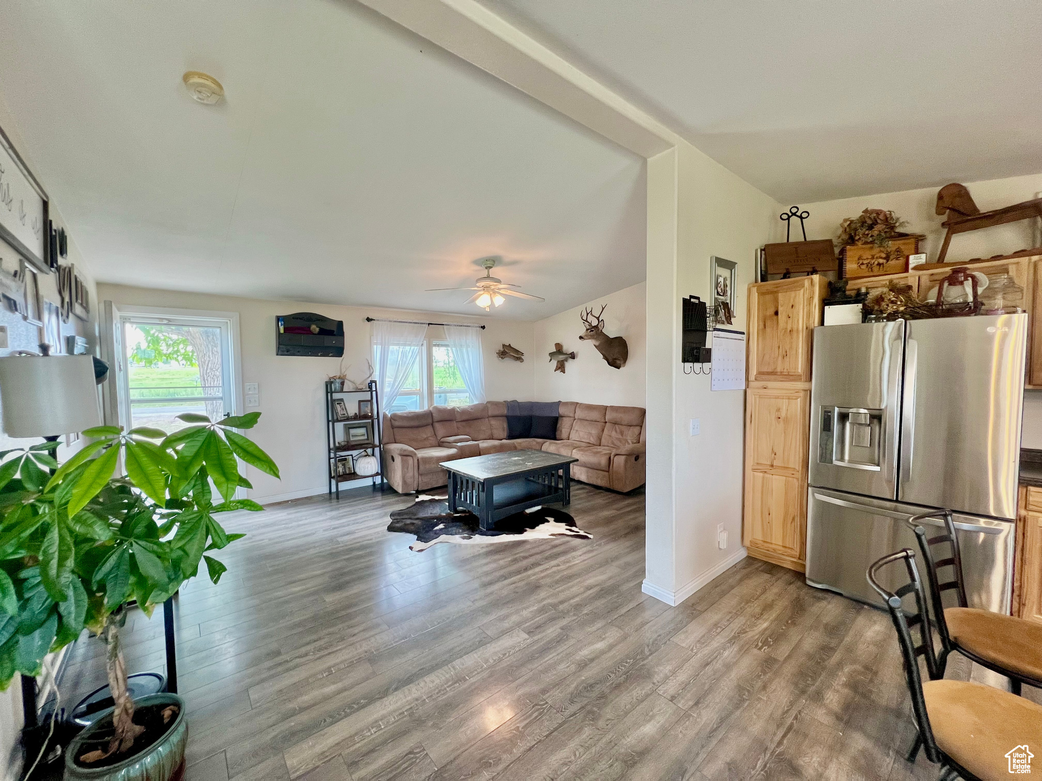 Living room featuring a wealth of natural light, ceiling fan, and wood finished floors