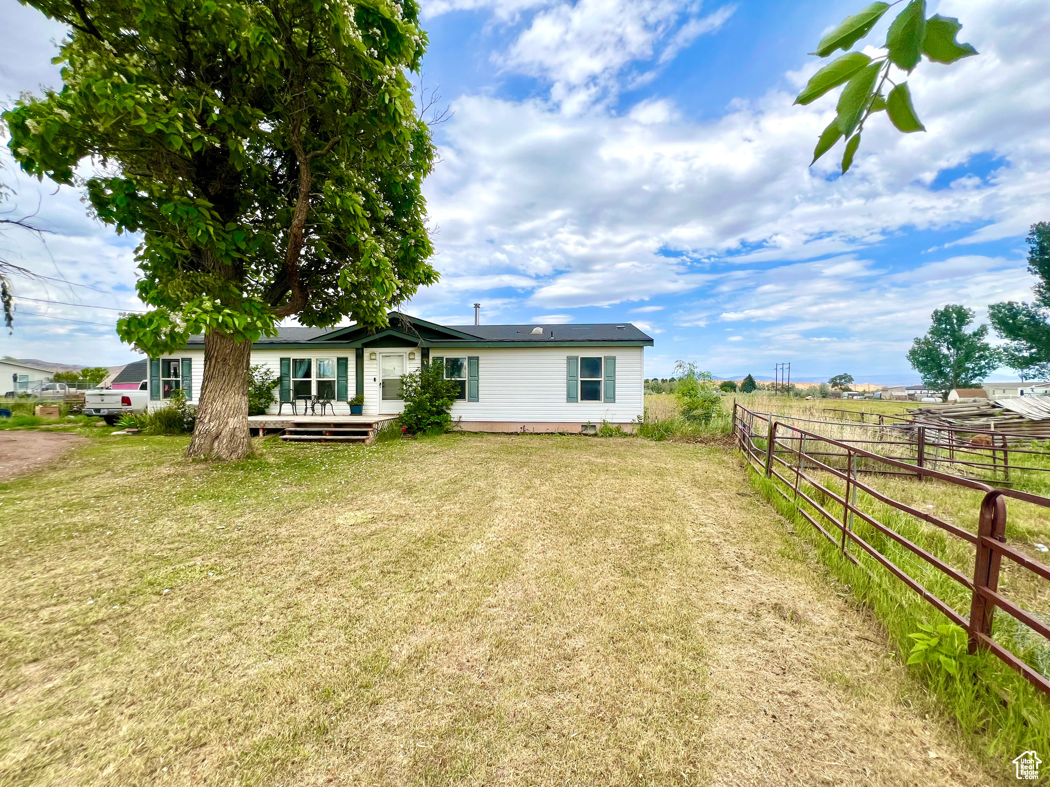 Back of house featuring a deck, a yard, and fence