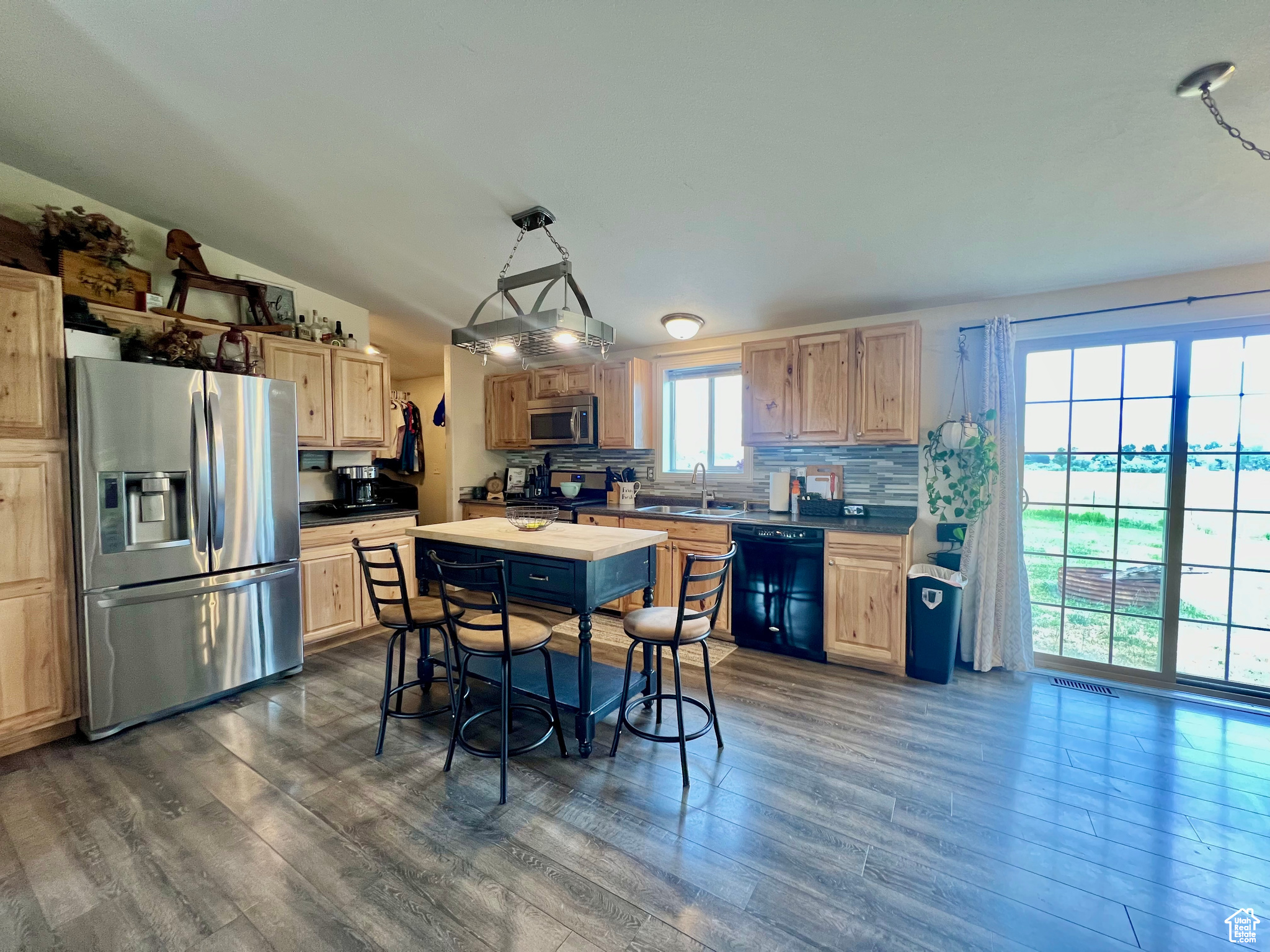 Kitchen featuring lofted ceiling, dark wood-style flooring, appliances with stainless steel finishes, and a sink