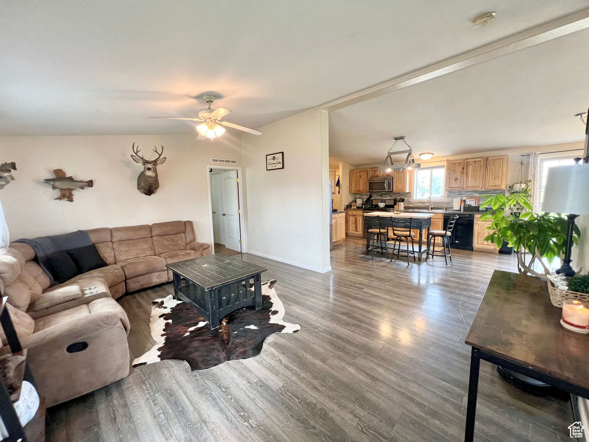 Living area featuring visible vents, baseboards, light wood finished floors, and ceiling fan