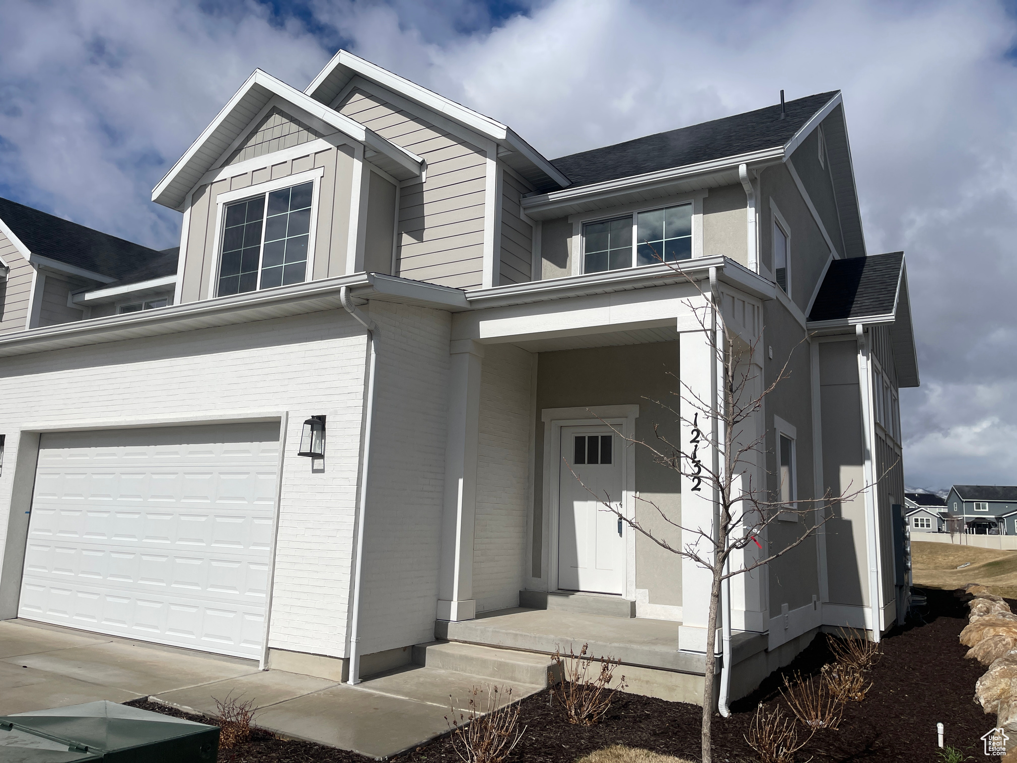 View of side of home featuring brick siding, driveway, and a garage
