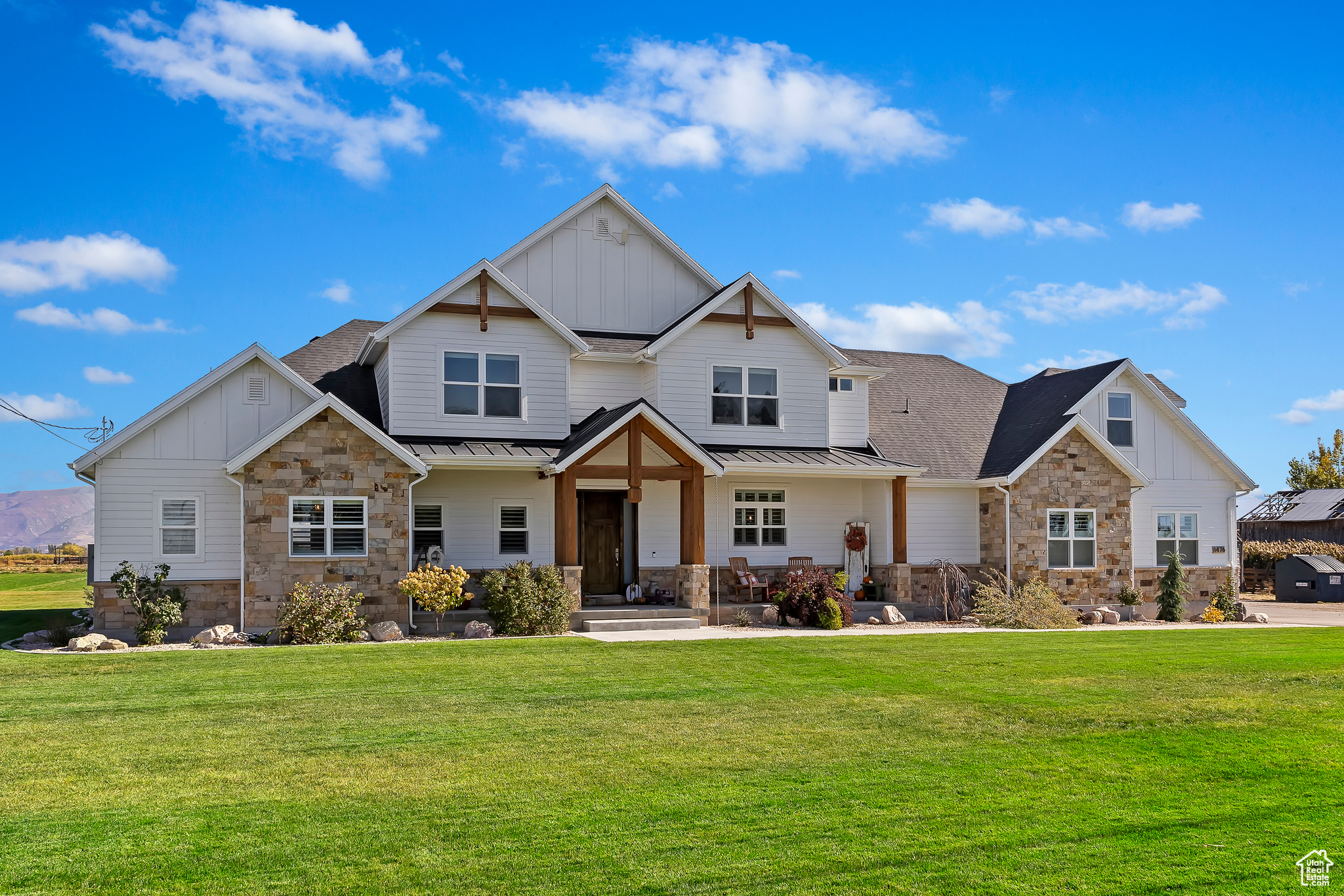 Craftsman house with stone siding, board and batten siding, and a front yard