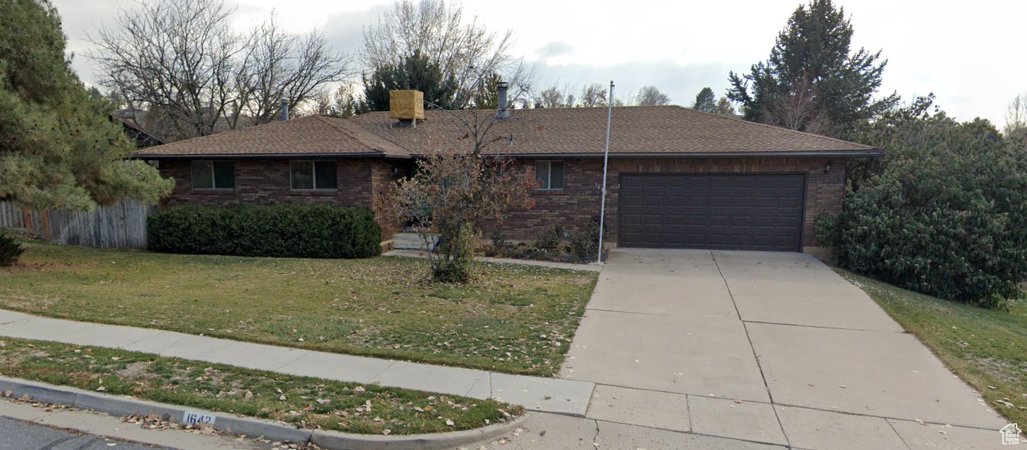 Ranch-style home featuring concrete driveway, an attached garage, a front yard, flag pole, brick siding, and a brand new shingled roof.