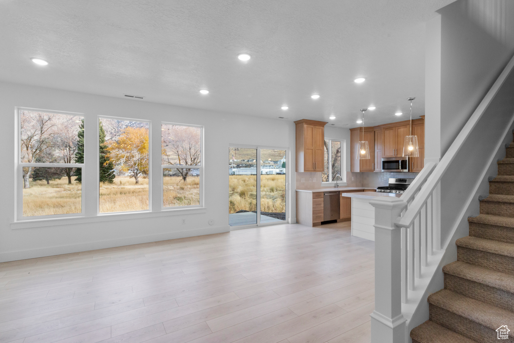 Kitchen featuring recessed lighting, appliances with stainless steel finishes, light wood-style flooring, and light countertops