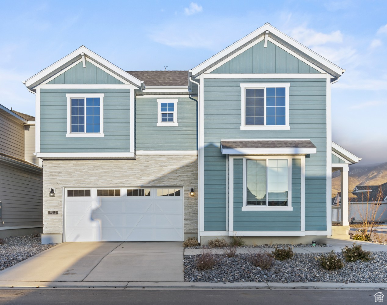 View of front of house with driveway, board and batten siding, and an attached garage