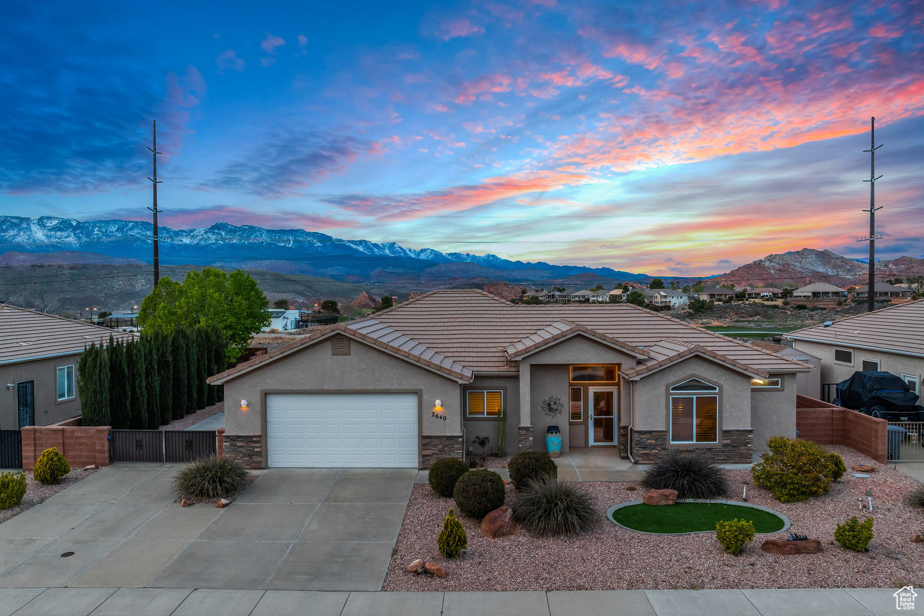 View of front of property with a mountain view, stone siding, and a gate