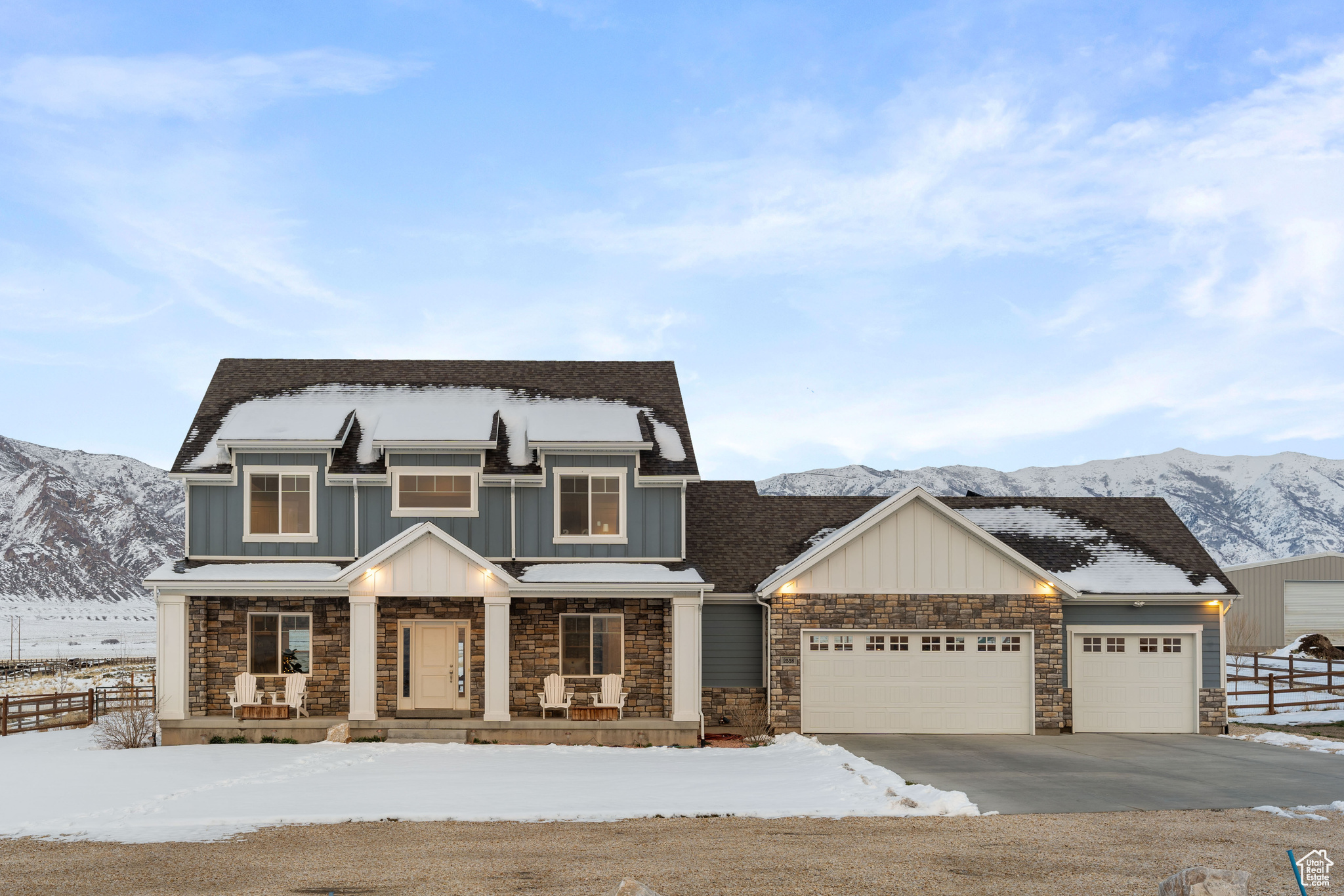 View of front of house with a porch, stone siding, board and batten siding, and concrete driveway