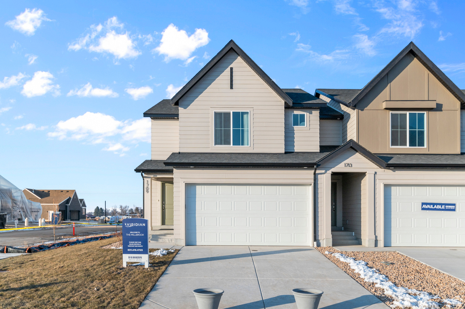 View of front of property featuring a garage, driveway, and a shingled roof