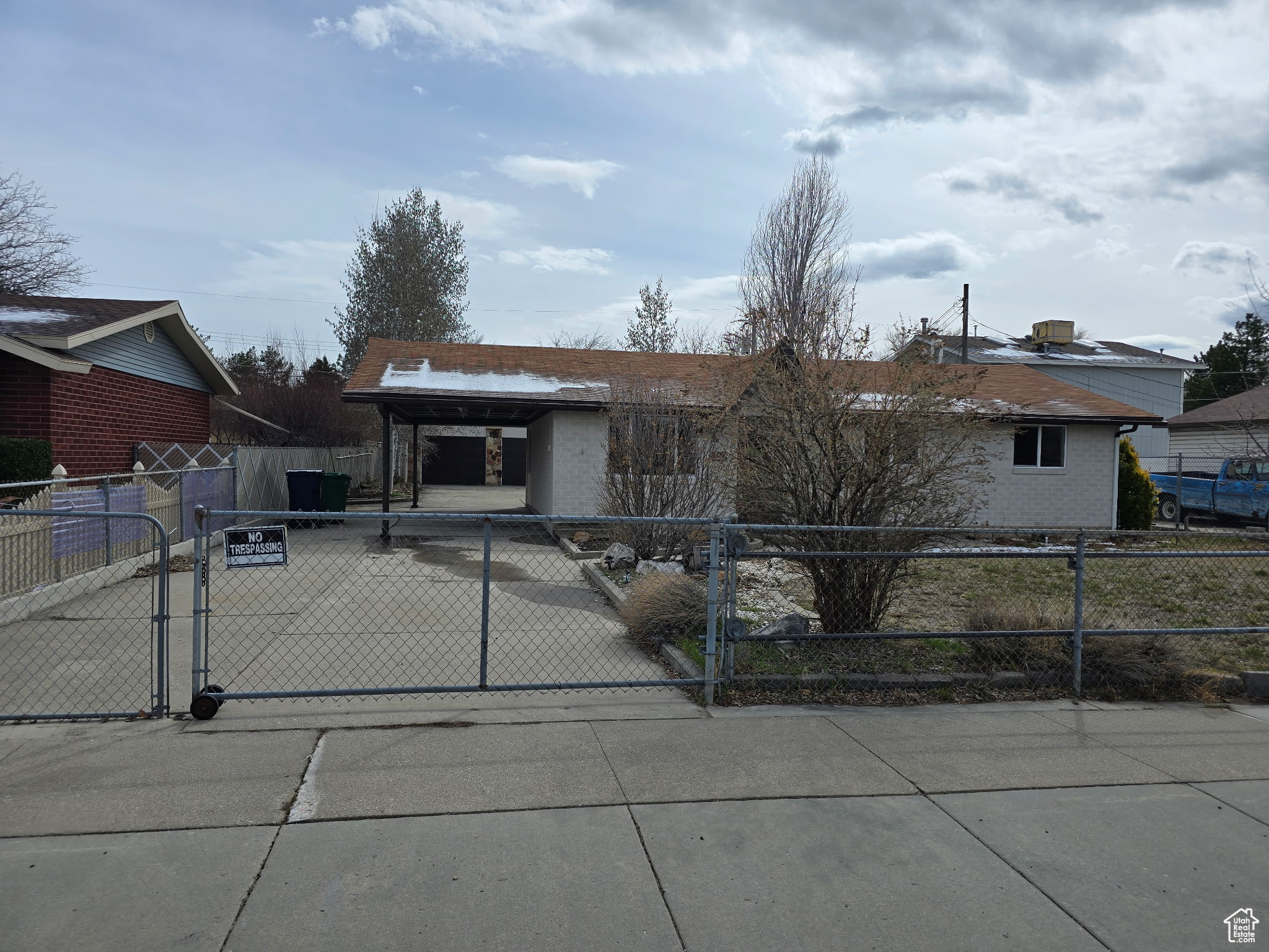 View of front of house featuring fence private yard, brick siding, a gate, and concrete driveway