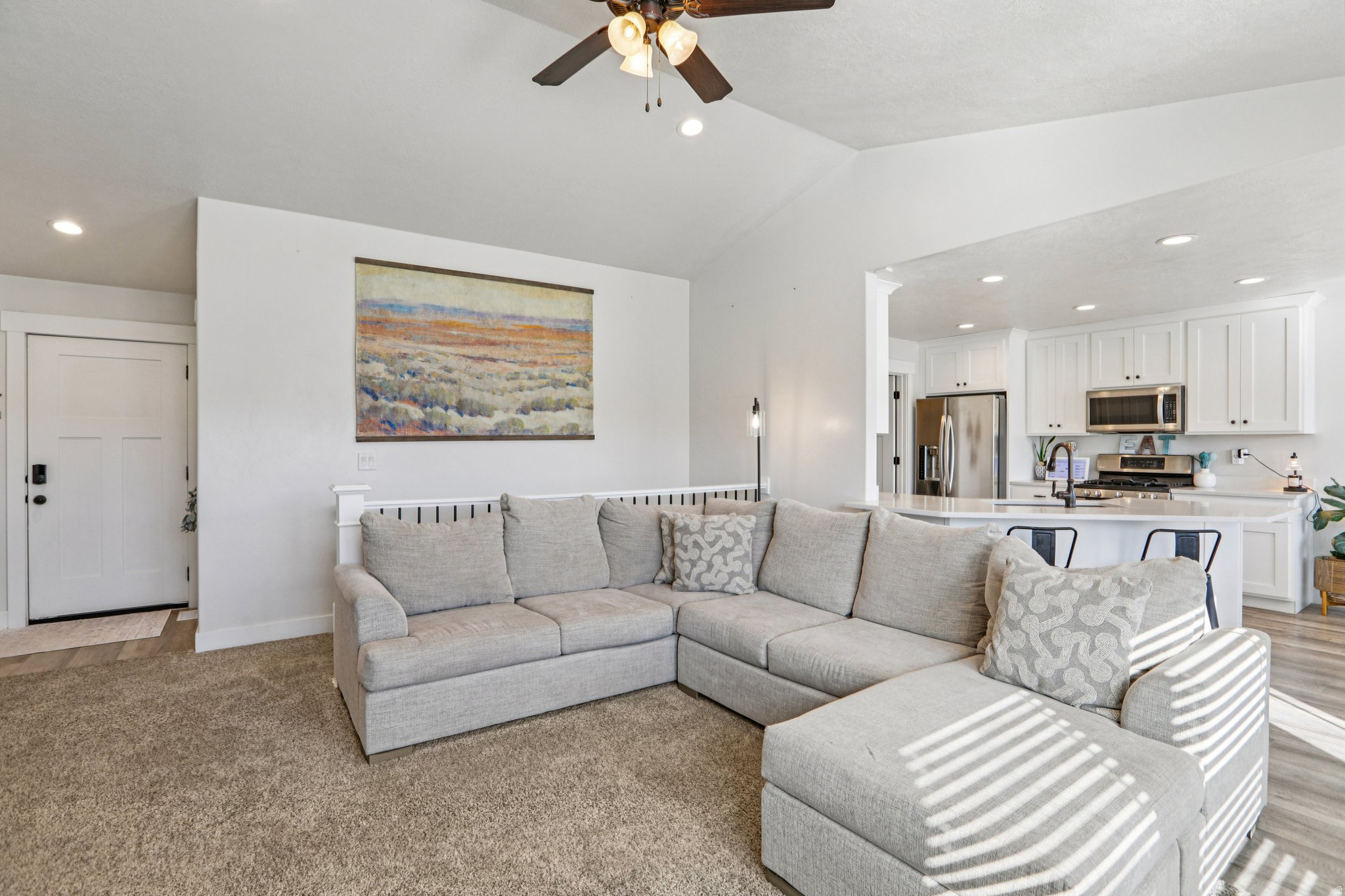 Living area with a ceiling fan, recessed lighting, and lofted ceiling