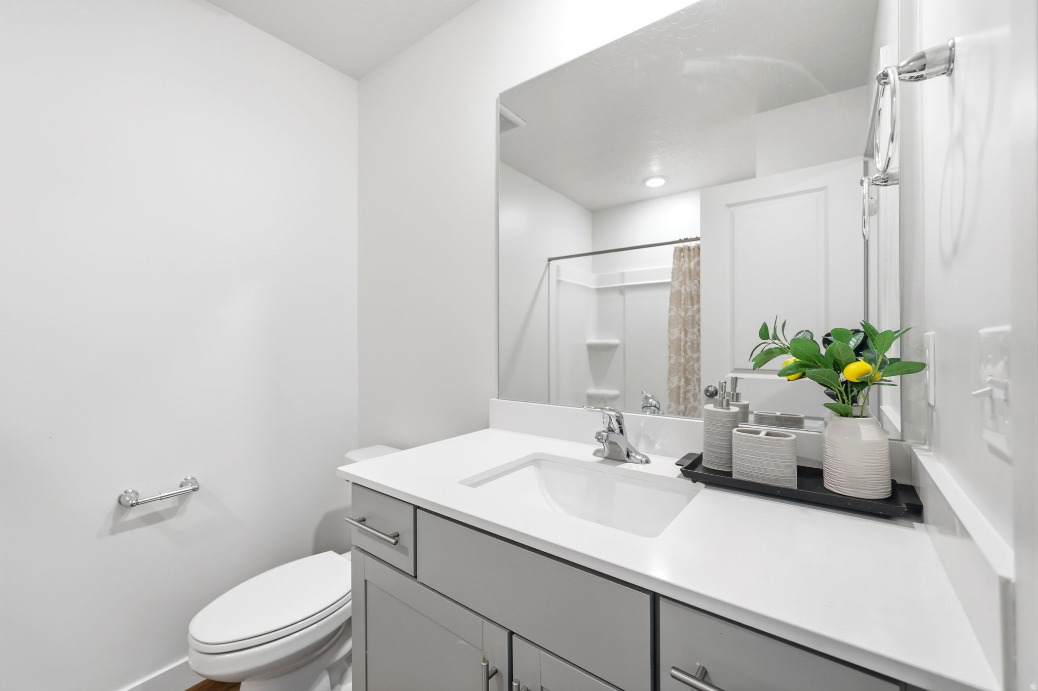 Modern bathroom featuring a single-sink vanity with light gray cabinetry, white countertop, and an integrated rectangular sink