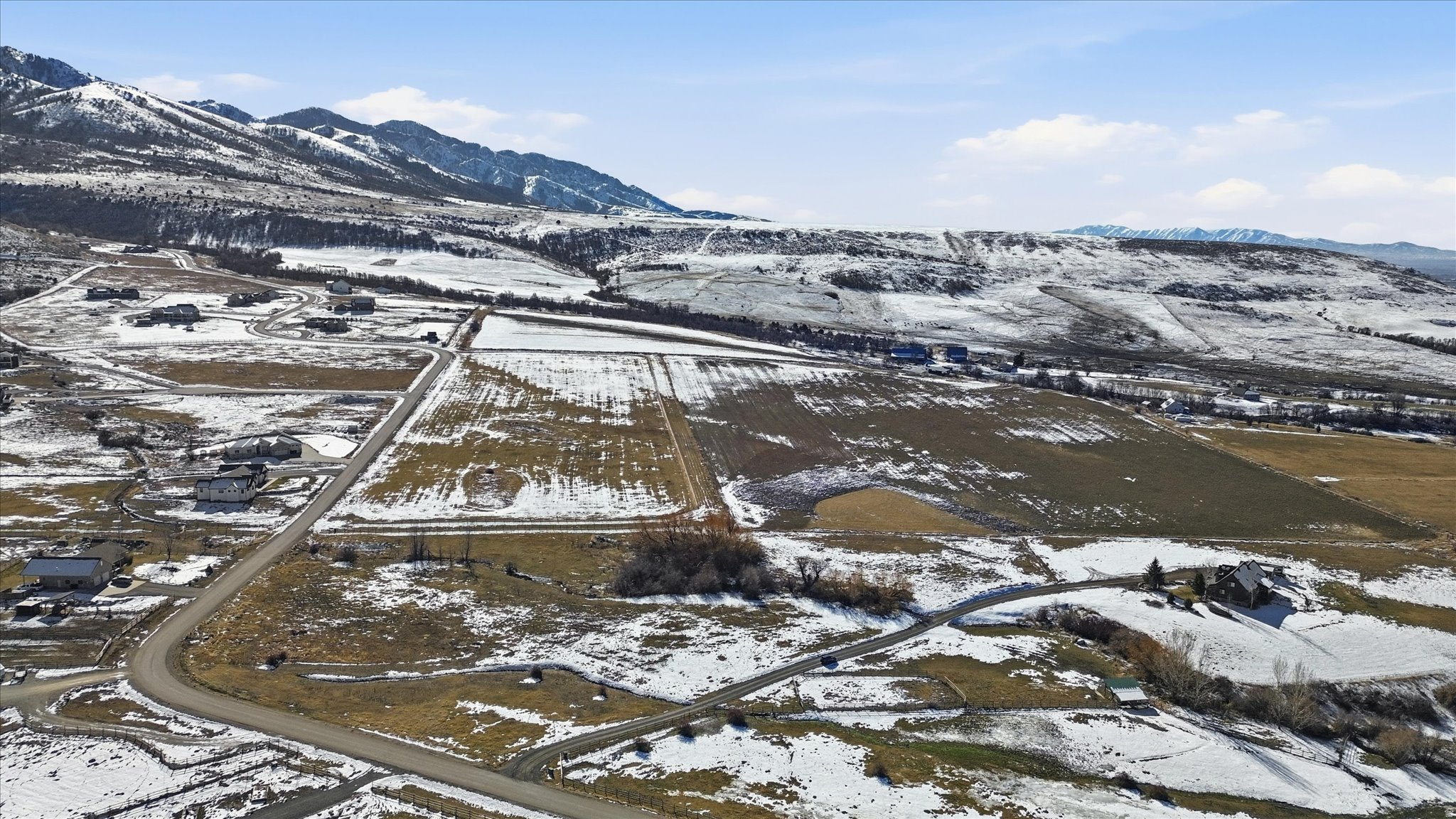 Expansive aerial perspective showcasing a mountainous backdrop and rolling terrain