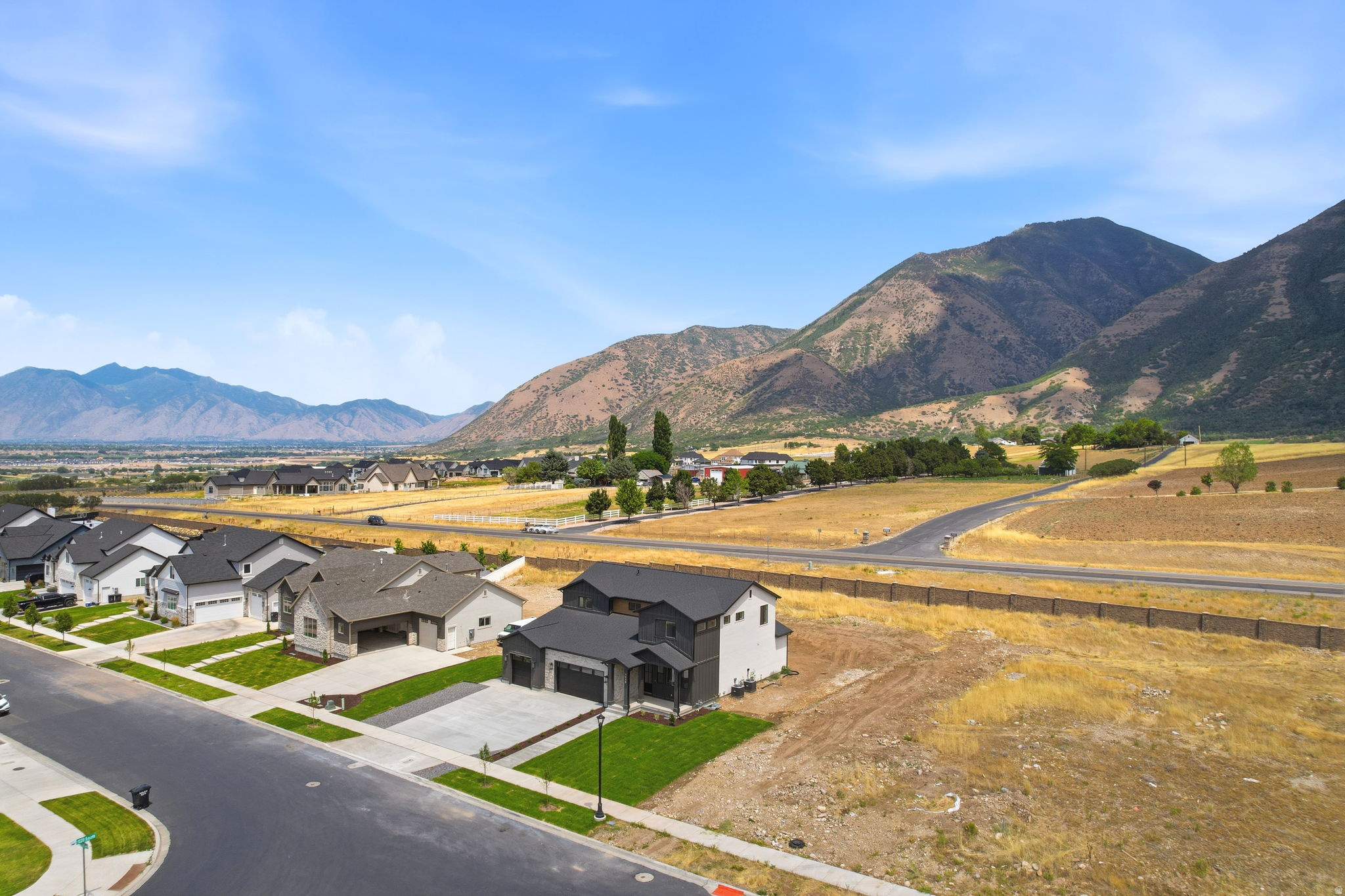 Modern residential development with mountain backdrop and clear skies