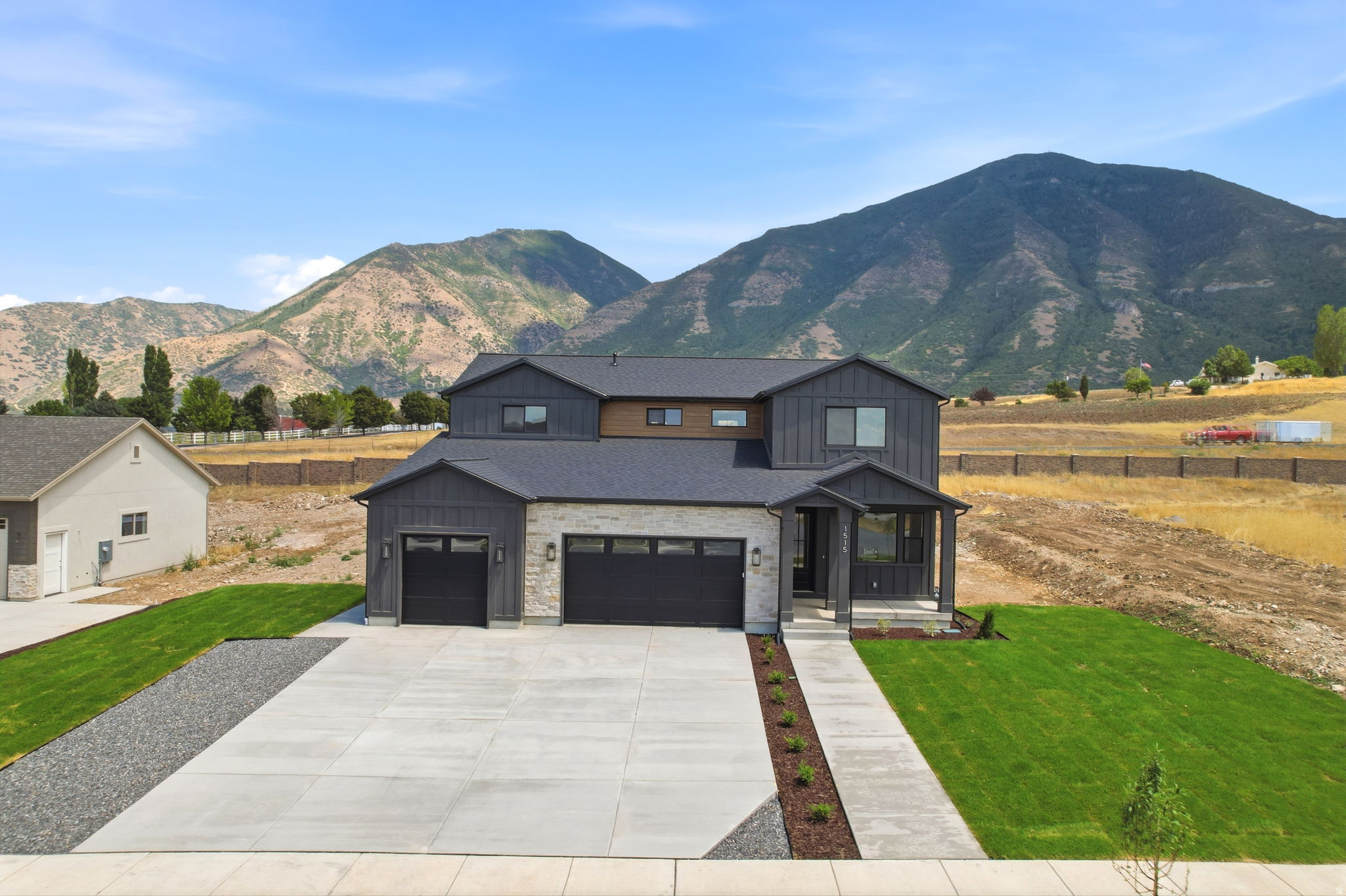 Modern two-story residence with a stone and dark siding exterior