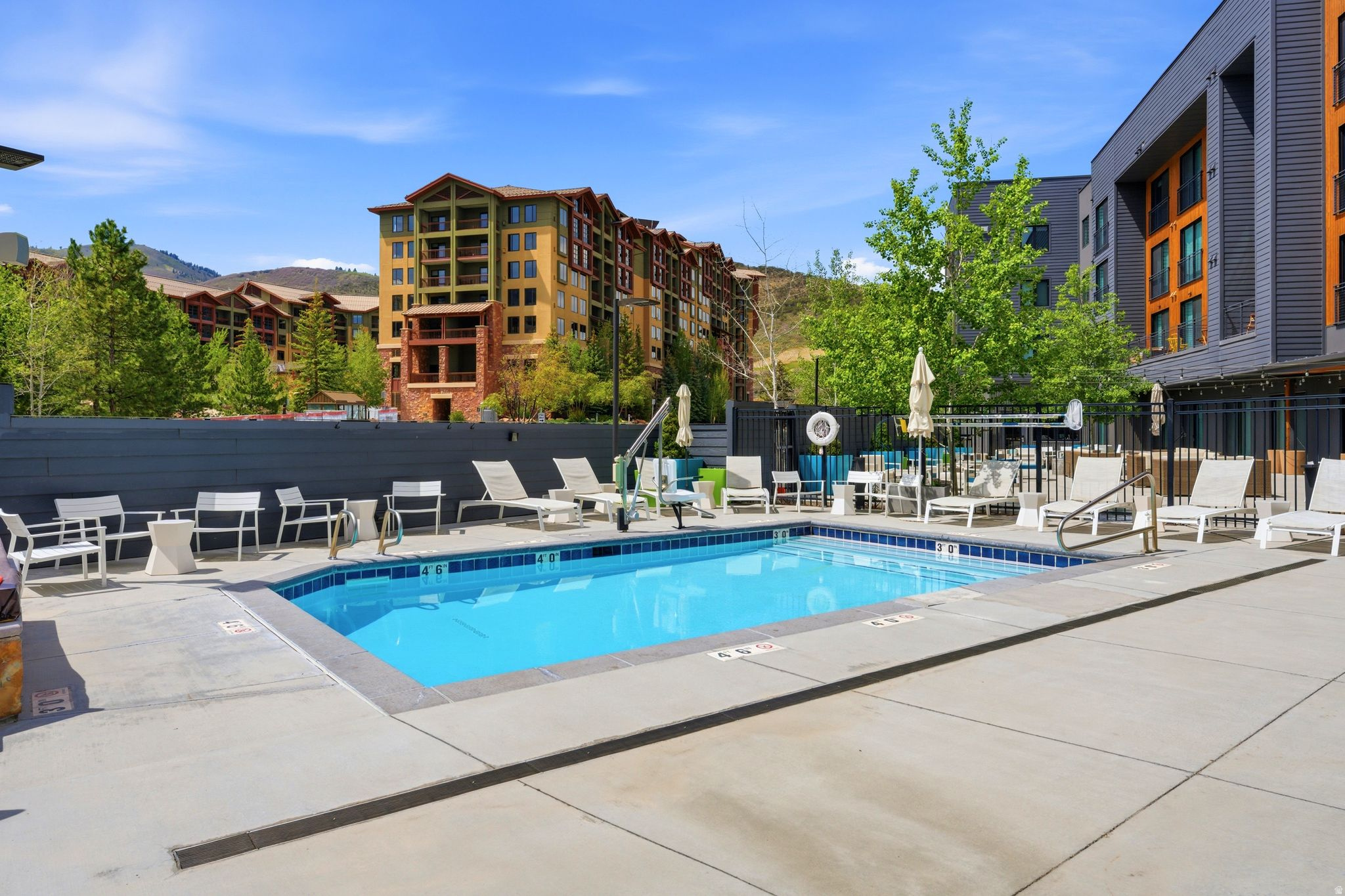 Outdoor swimming pool with integrated steps and surrounding concrete patio