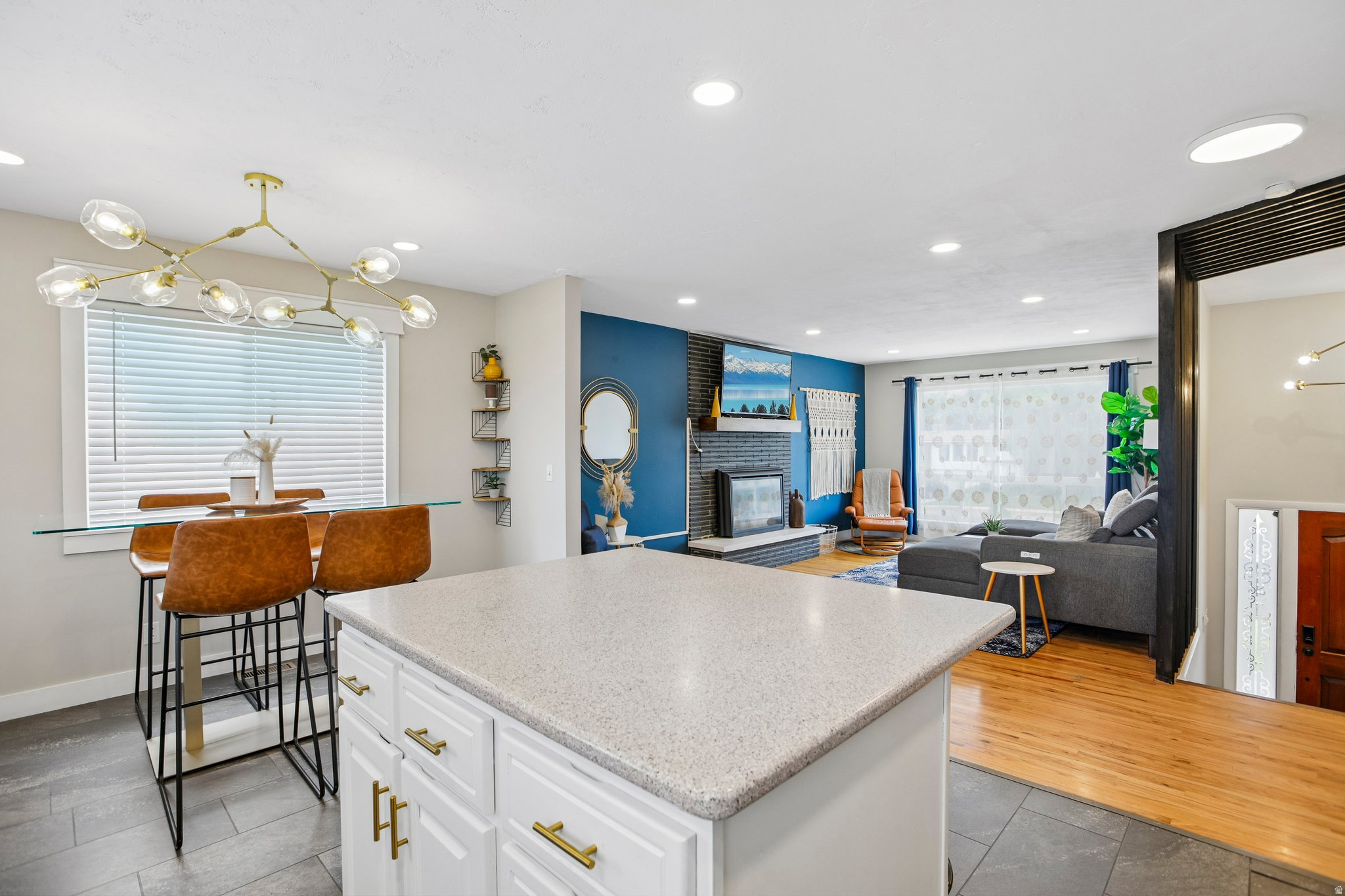 Kitchen island with a light-colored countertop, white cabinetry, and gold-tone hardware