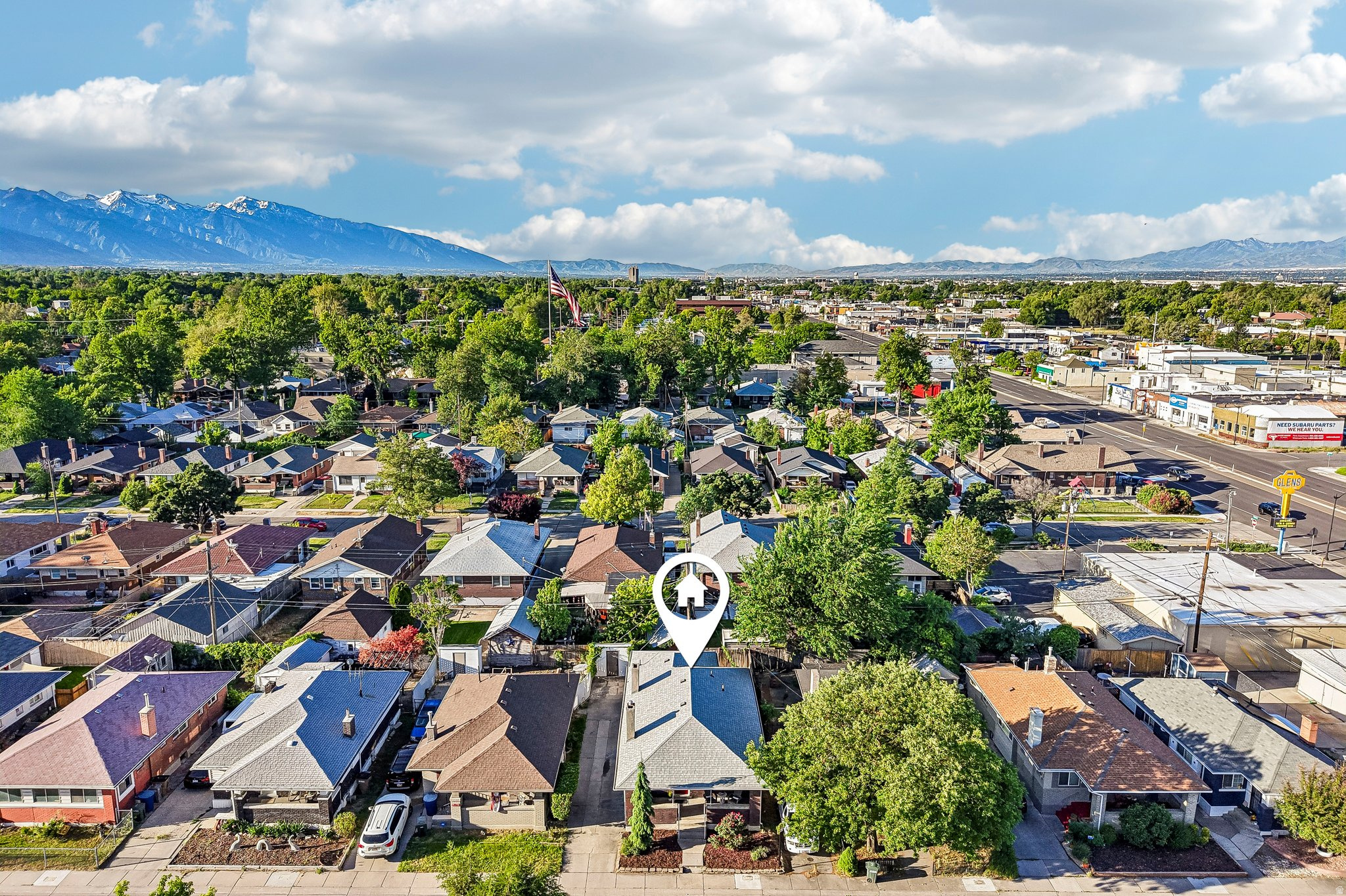 Residential neighborhood featuring a diverse collection of homes, mature trees, and mountainous terrain in the distance