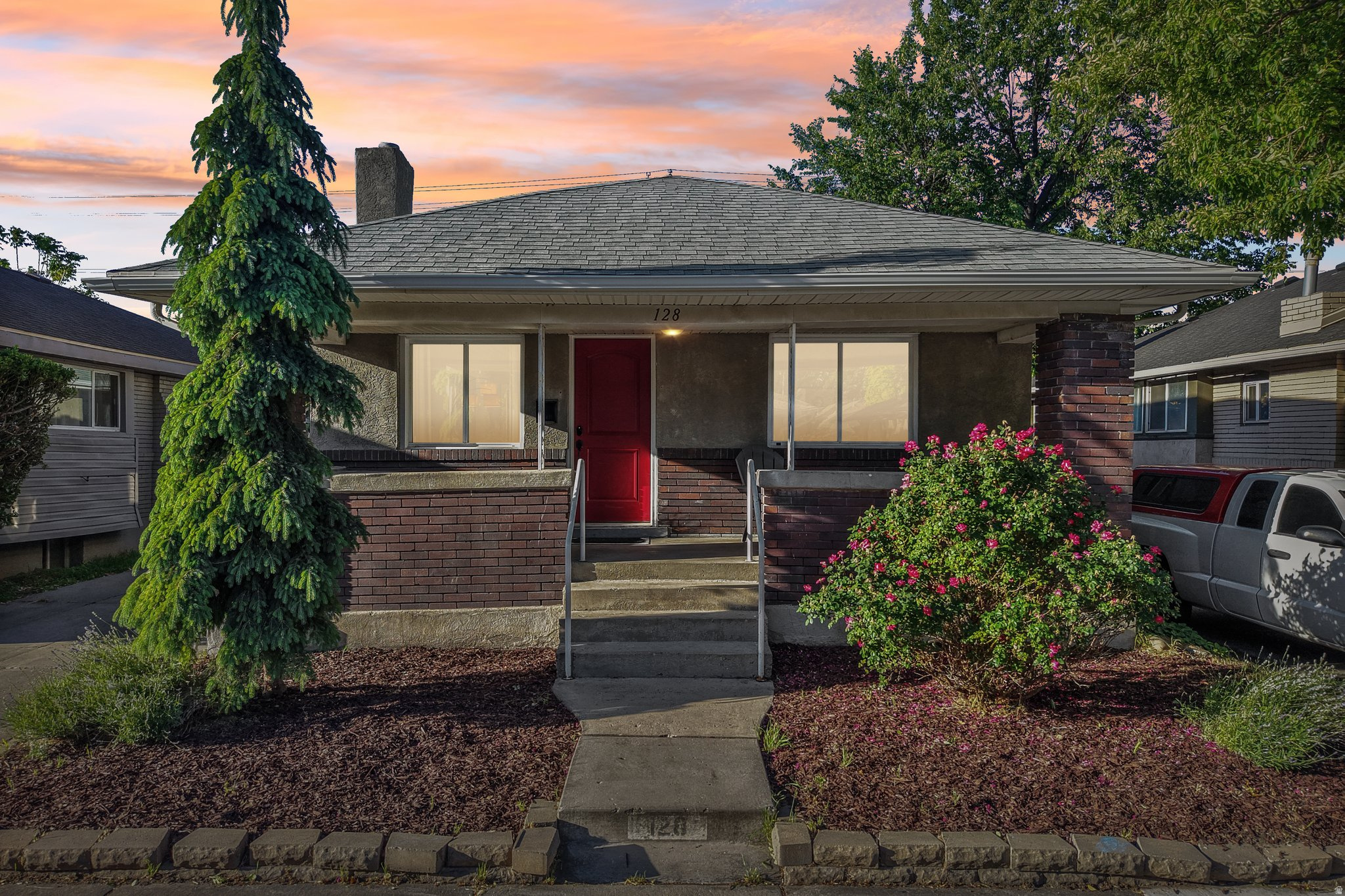 Charming single-story residence featuring a prominent red entry door and a covered front porch
