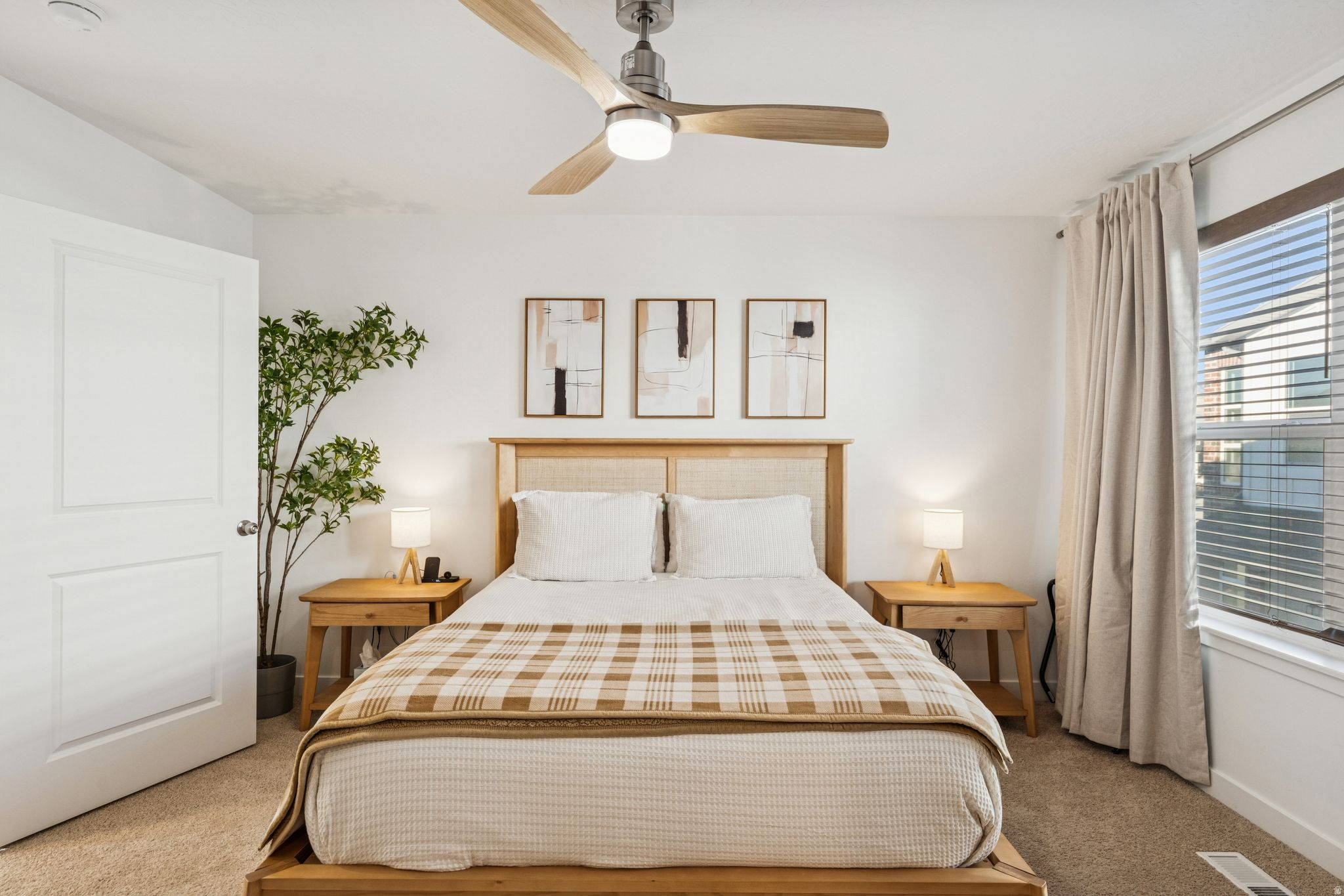 Bedroom featuring a ceiling fan with integrated lighting, a window with blinds and drapes, and neutral wall tones
