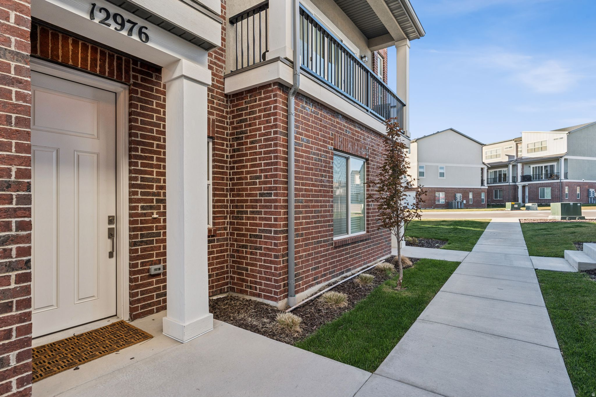 Brick exterior featuring a white paneled entry door with dark hardware