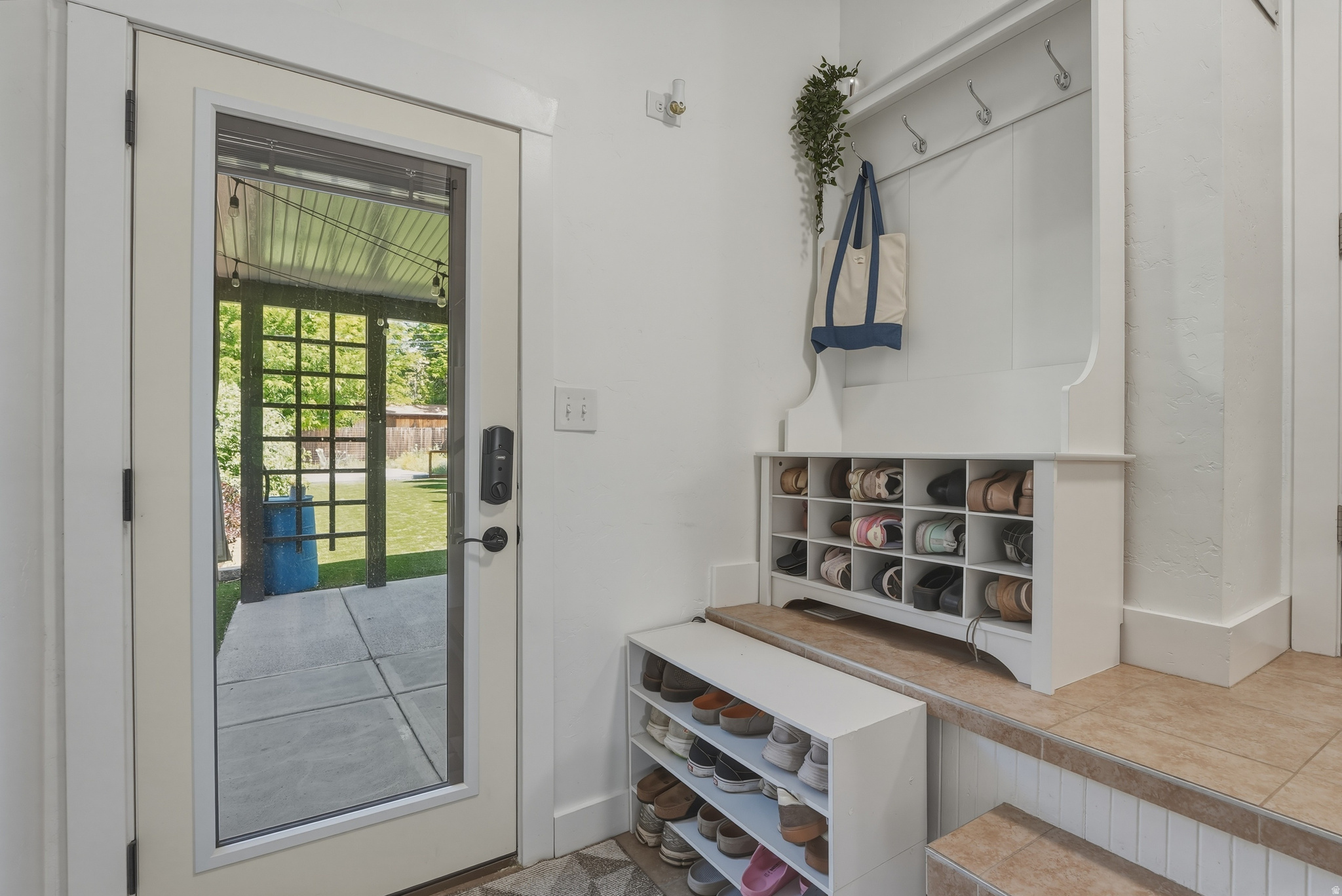 Full-lite door offering outdoor access to a covered patio and green space