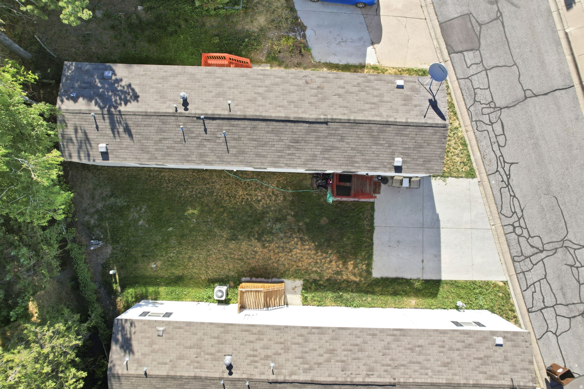 Aerial view showcasing two residential structures with asphalt shingle roofs