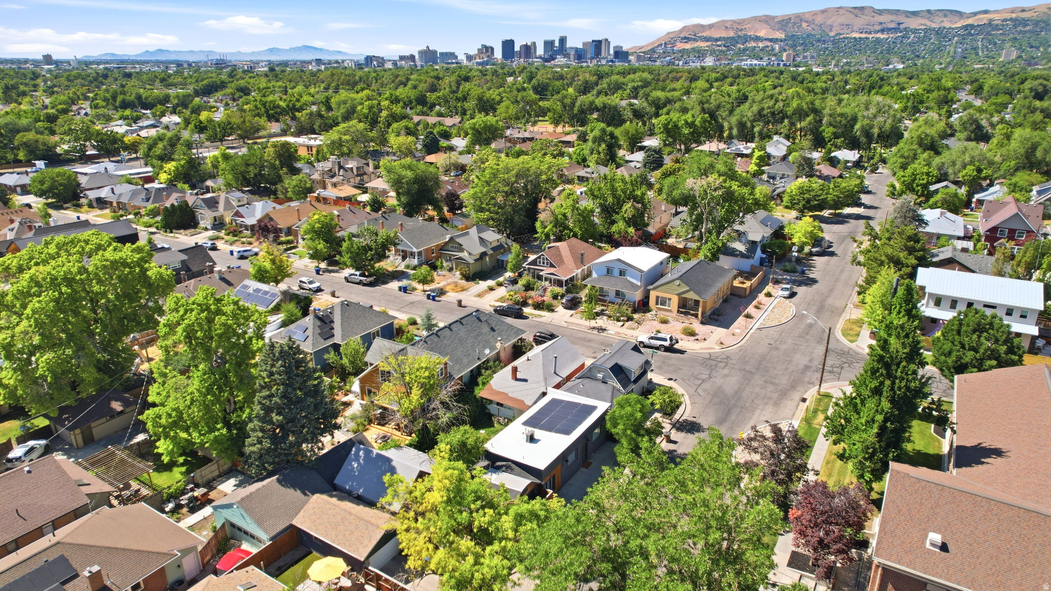 Aerial perspective showcasing a residential neighborhood with a distant cityscape and mountain range