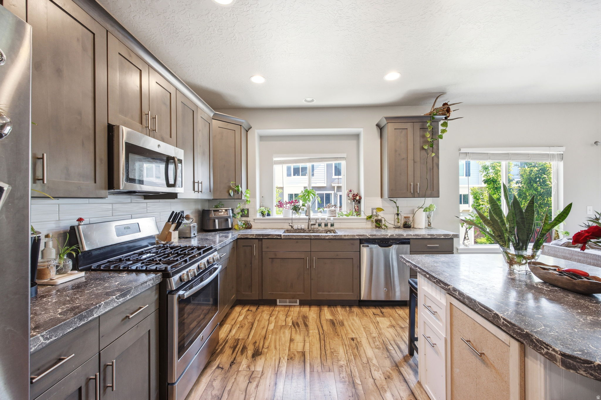 Contemporary kitchen featuring wood-finish flooring and recessed lighting